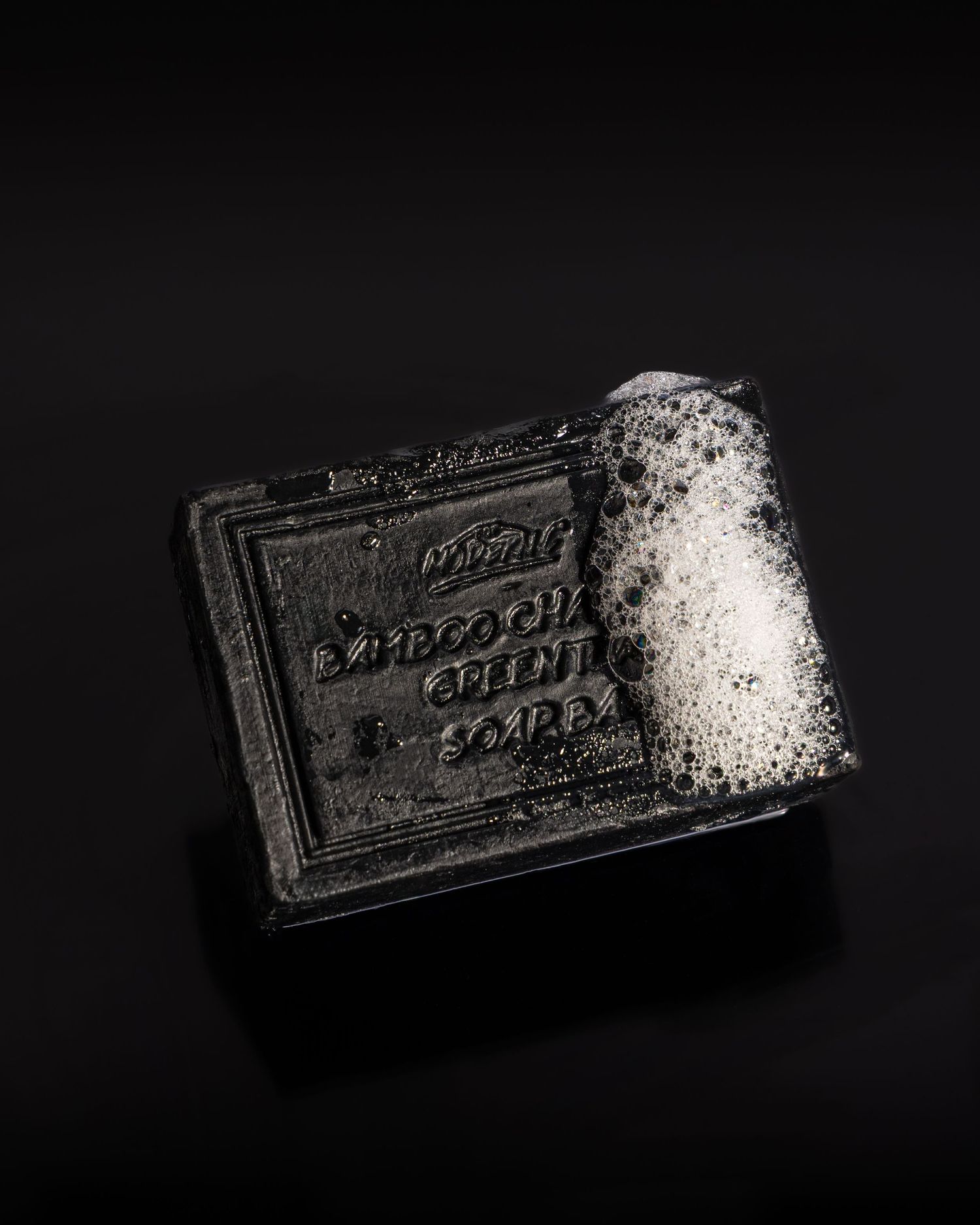 A black Oreo cookie broken in half with powdered sugar scattered on a dark background.
