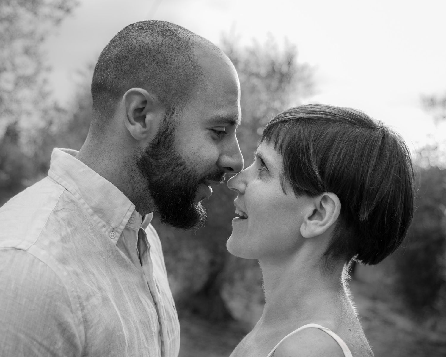 A couple shares intimate moments in a series of black and white photographs captured outdoors.