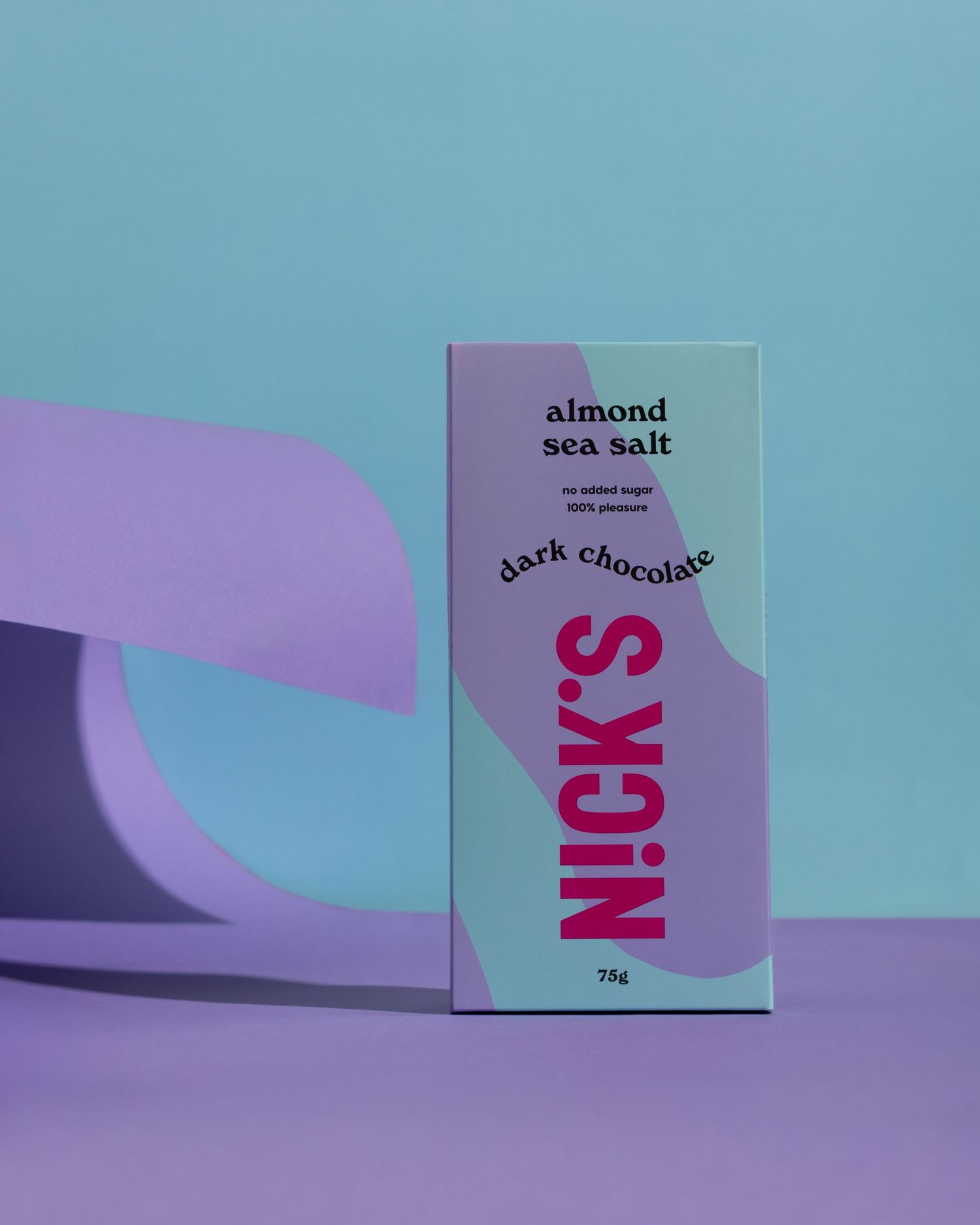 A pink and purple minimalist product packaging for Nick's almond sea salt dark chocolate bar against a blue backdrop.