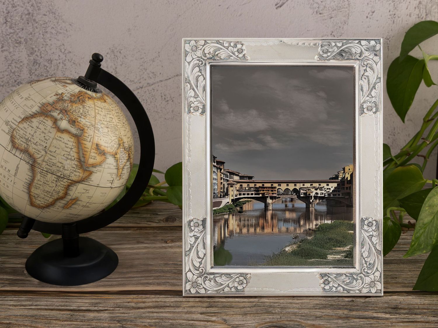 Vintage decorative objects including antique frames, globes, and maps arranged on wooden surfaces in a moody aesthetic.