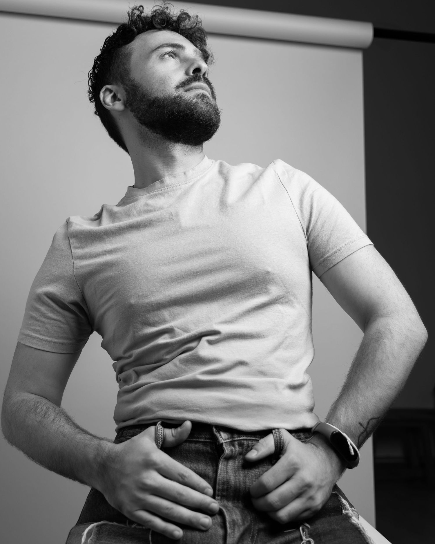 Series of black and white photographs showing person in white t-shirt posing against plain background.