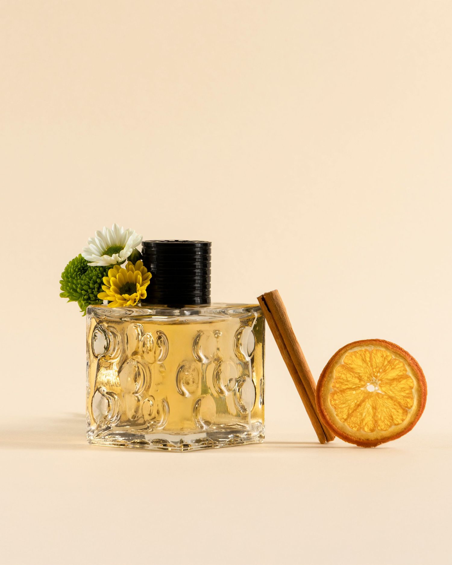 Glass jar with honey-colored cream and dried citrus slice garnish against a neutral beige background.