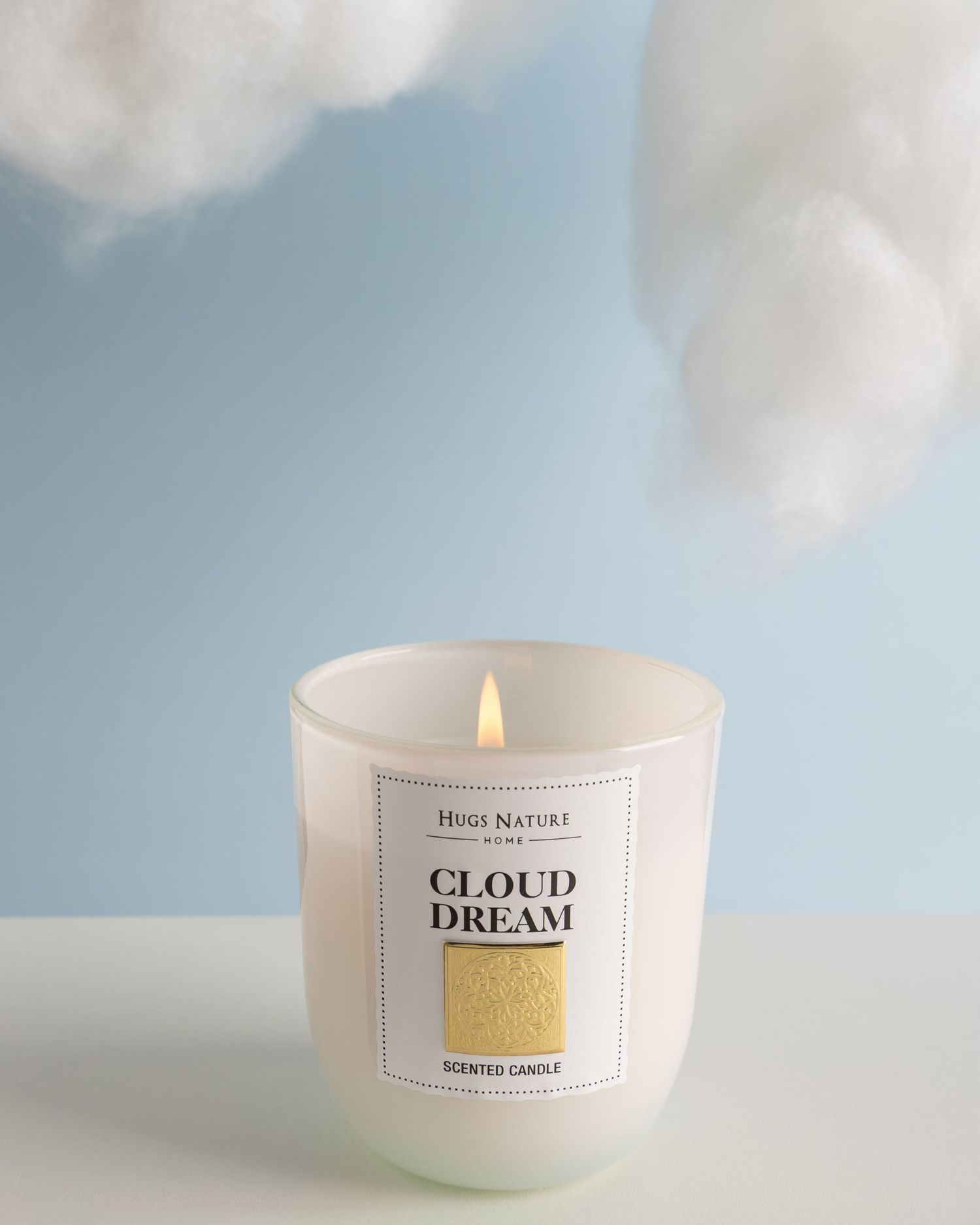 A minimalist white scented candle with 'Cloud Dream' text sits against a dreamy cloudy sky background.