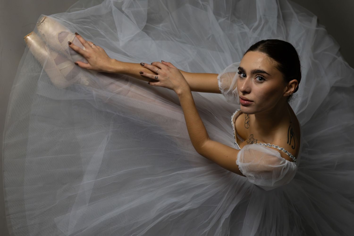 Classical ballet dancer in white tutu photographed from above.
