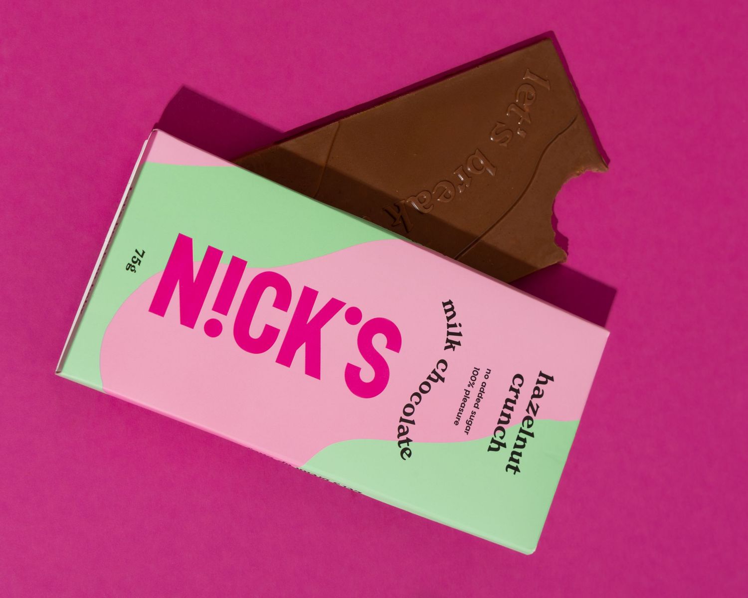 Several chocolate bars with green and pink labels arranged in a sequence against a vibrant pink background.