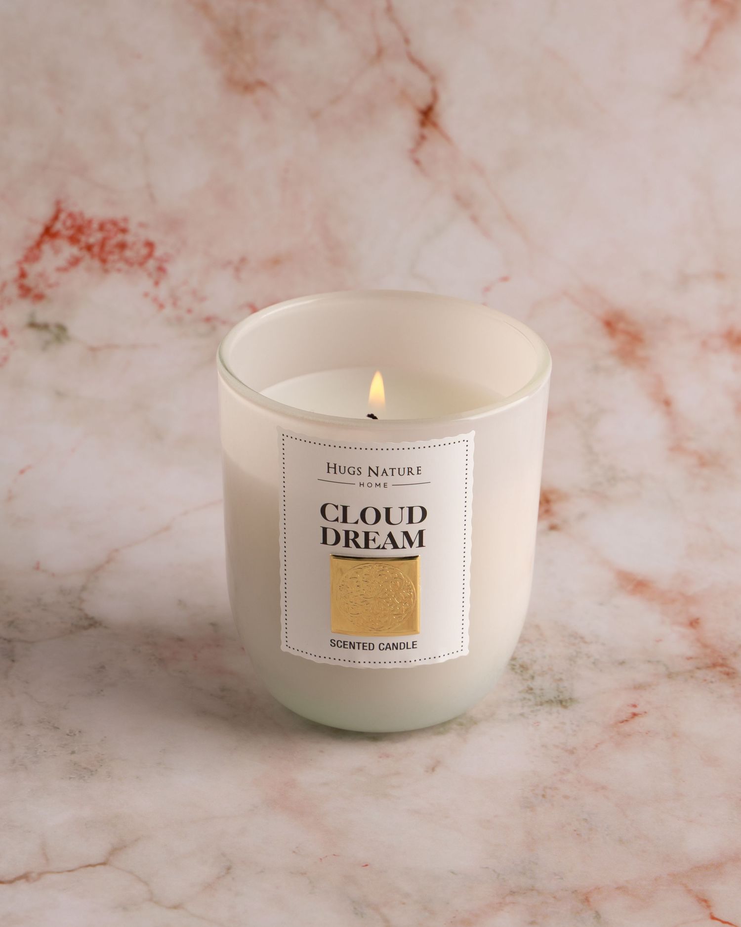 White scented candle with minimal label design shown in sequence on pink marble surface from different angles.