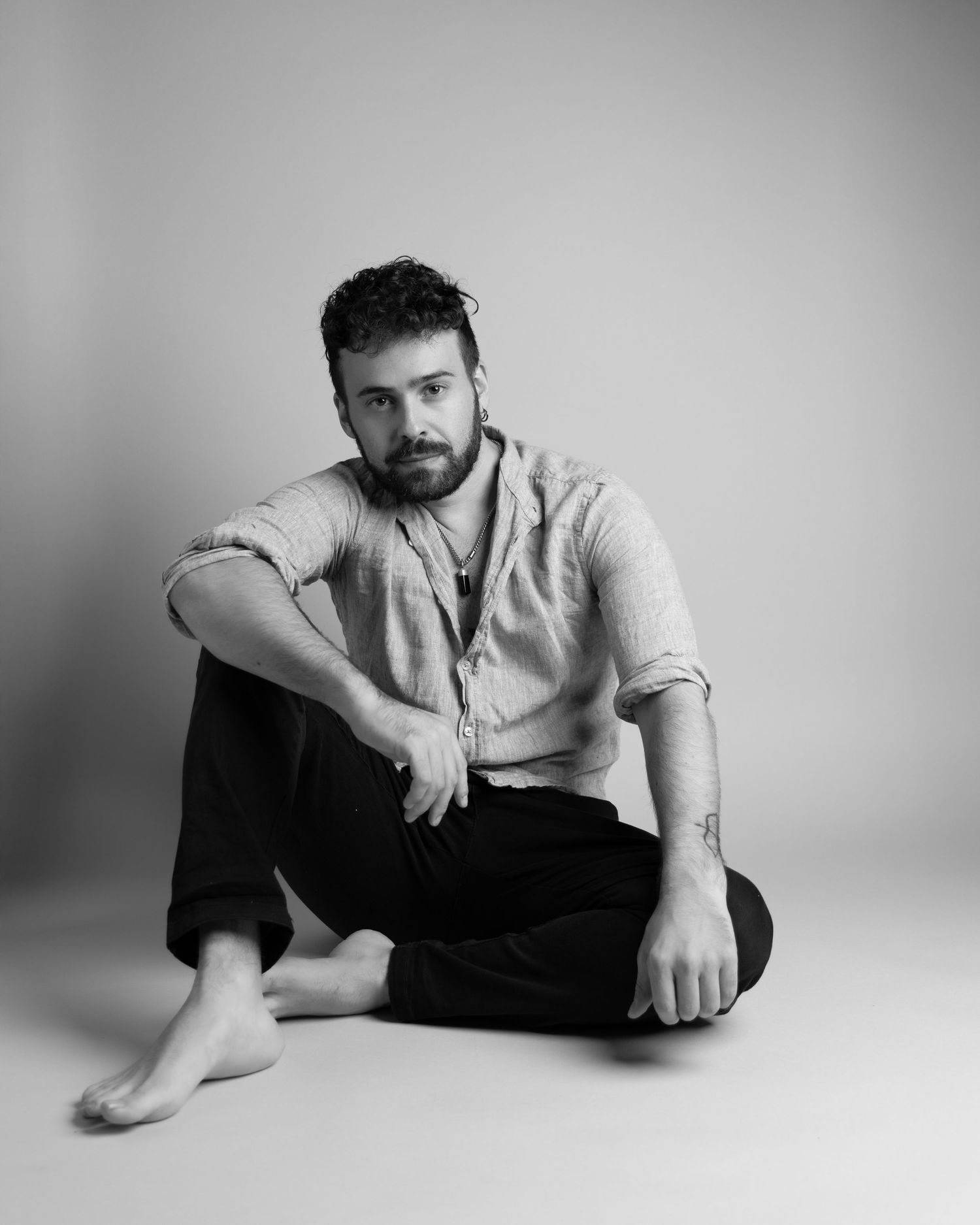 Black and white artistic portraits showing someone reclining and posing on floor in casual attire.