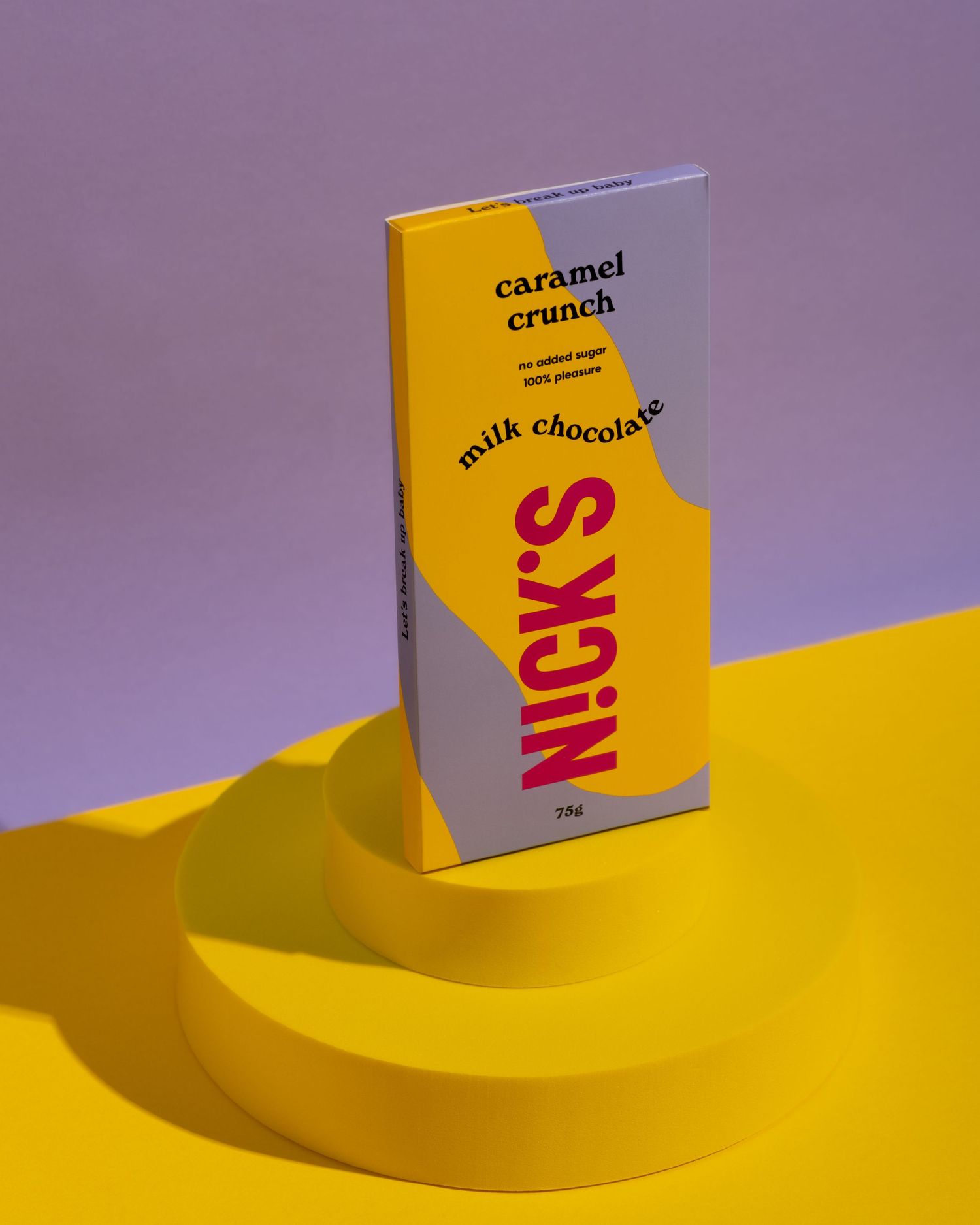 White milk chocolate bar packaging set against a vibrant yellow and purple background in a minimalist composition.