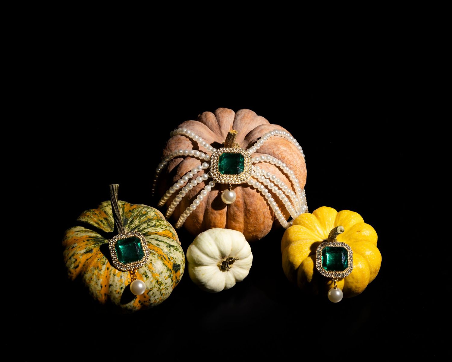 Artistic still life of orange and yellow pumpkins arranged on black background with dramatic lighting.