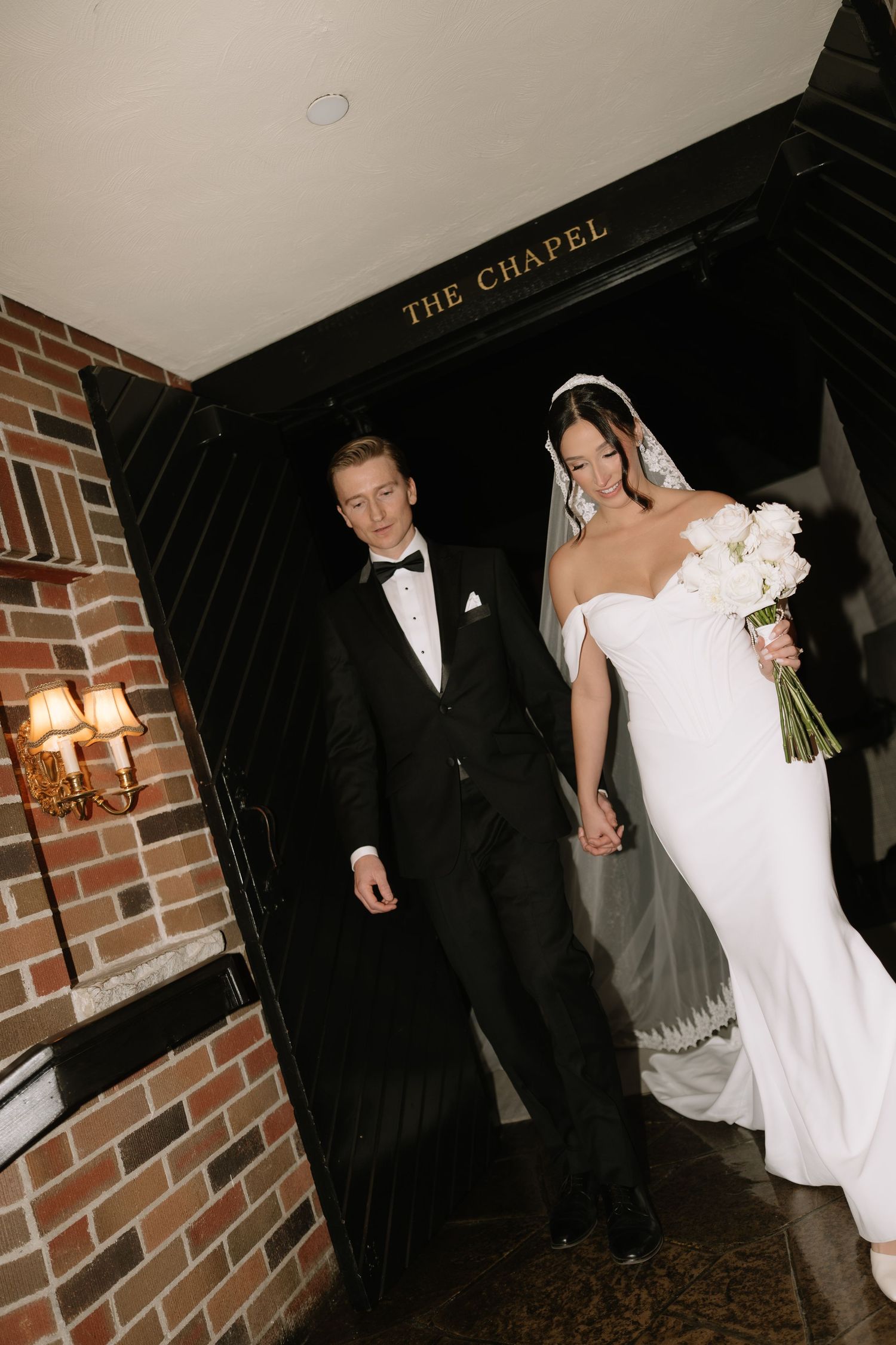 Newlyweds holding hands while exiting The Chapel after their wedding ceremony.