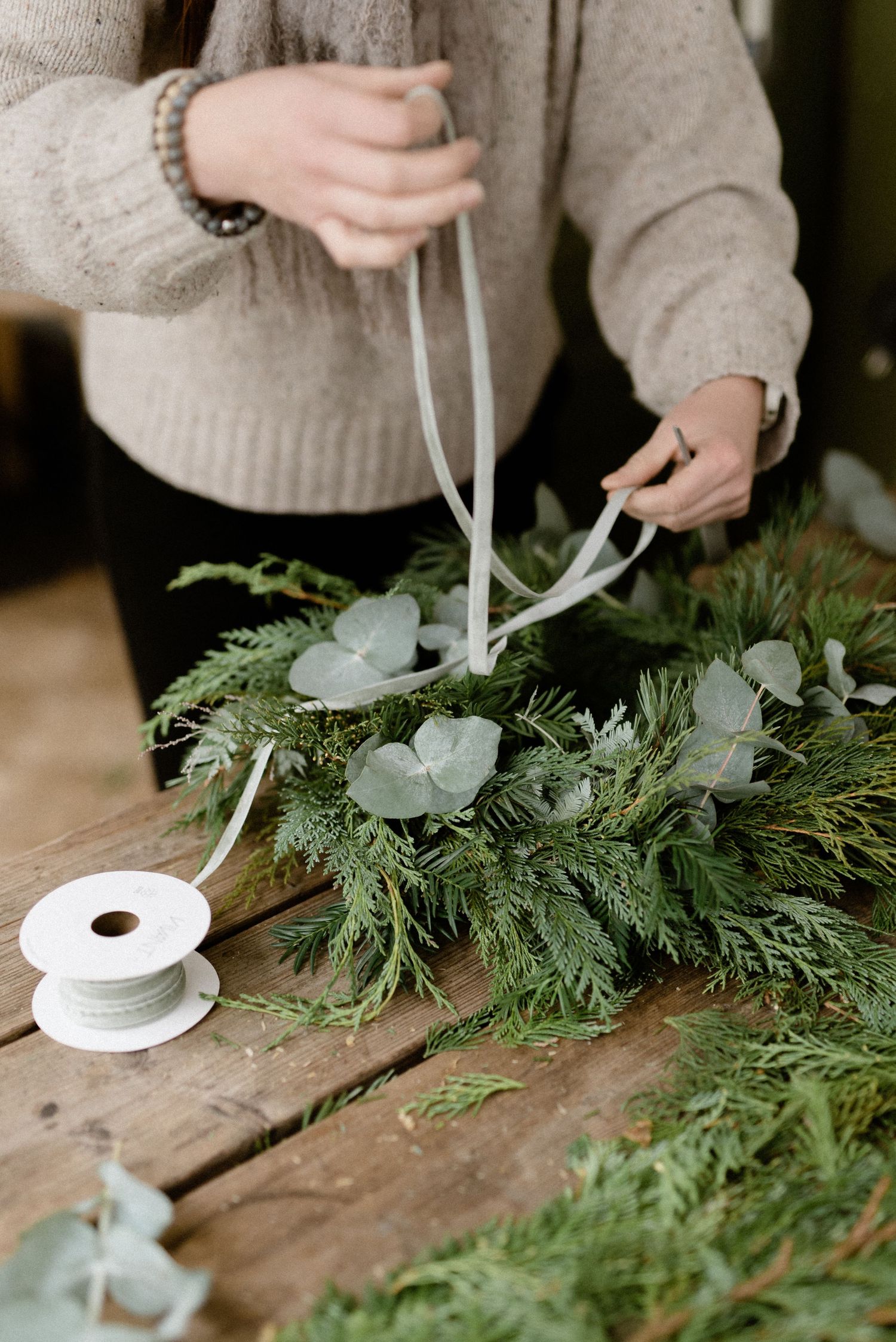 Yrittäjä sitoo kranssia joulumyyjäisiin