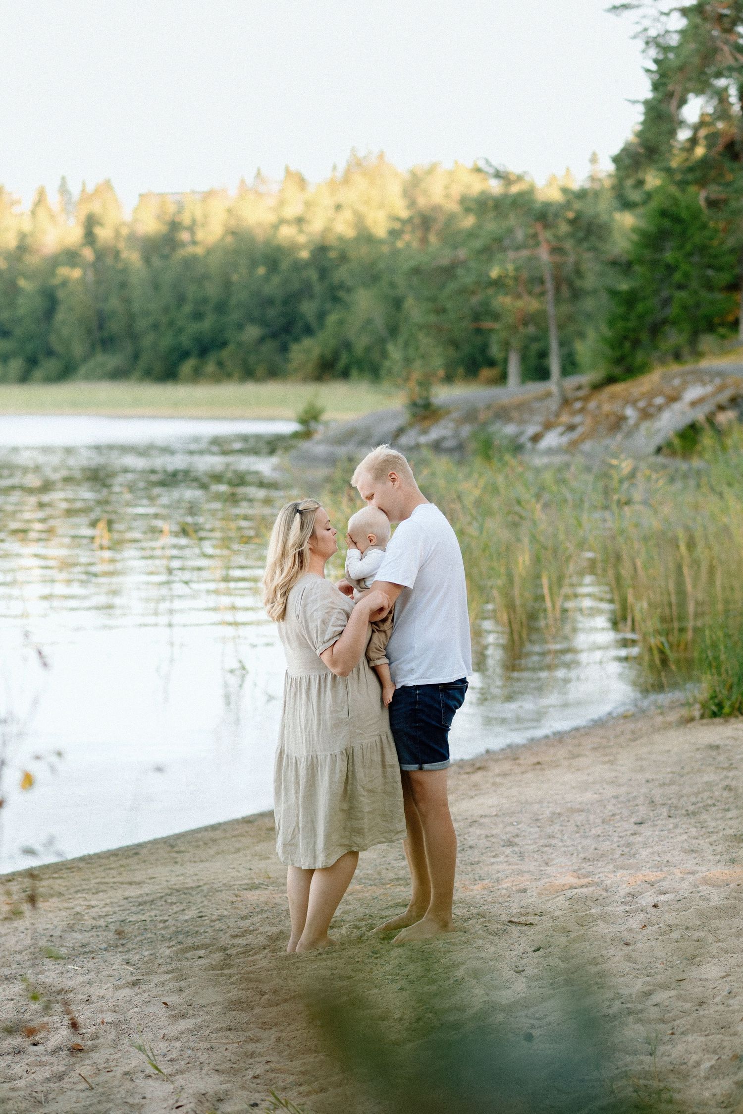 Perhekuva rannalla pienen lapsen kanssa