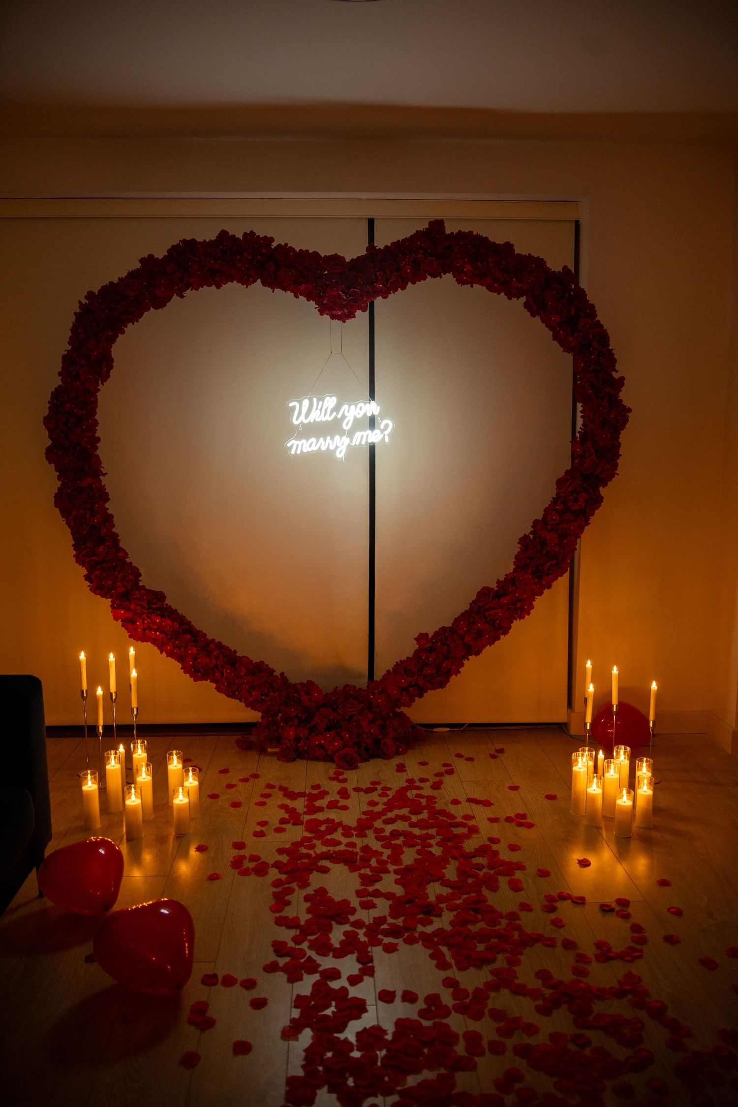 will you marry me proposal set up. heart made of red roses framing 