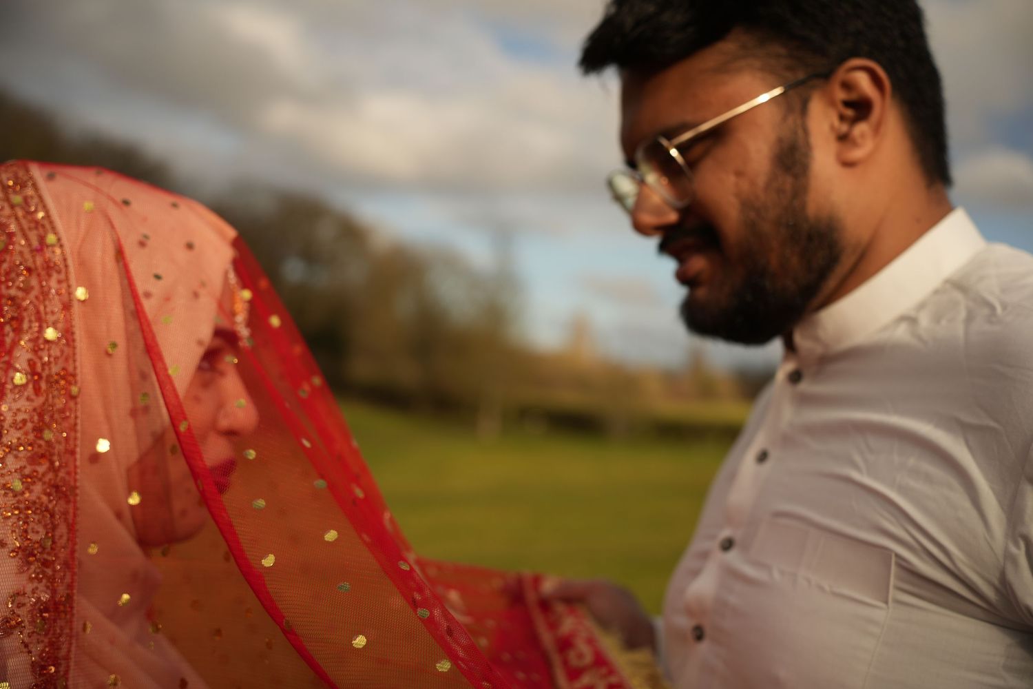 groom lifting red veil off bride. Tied in Time Photography.
