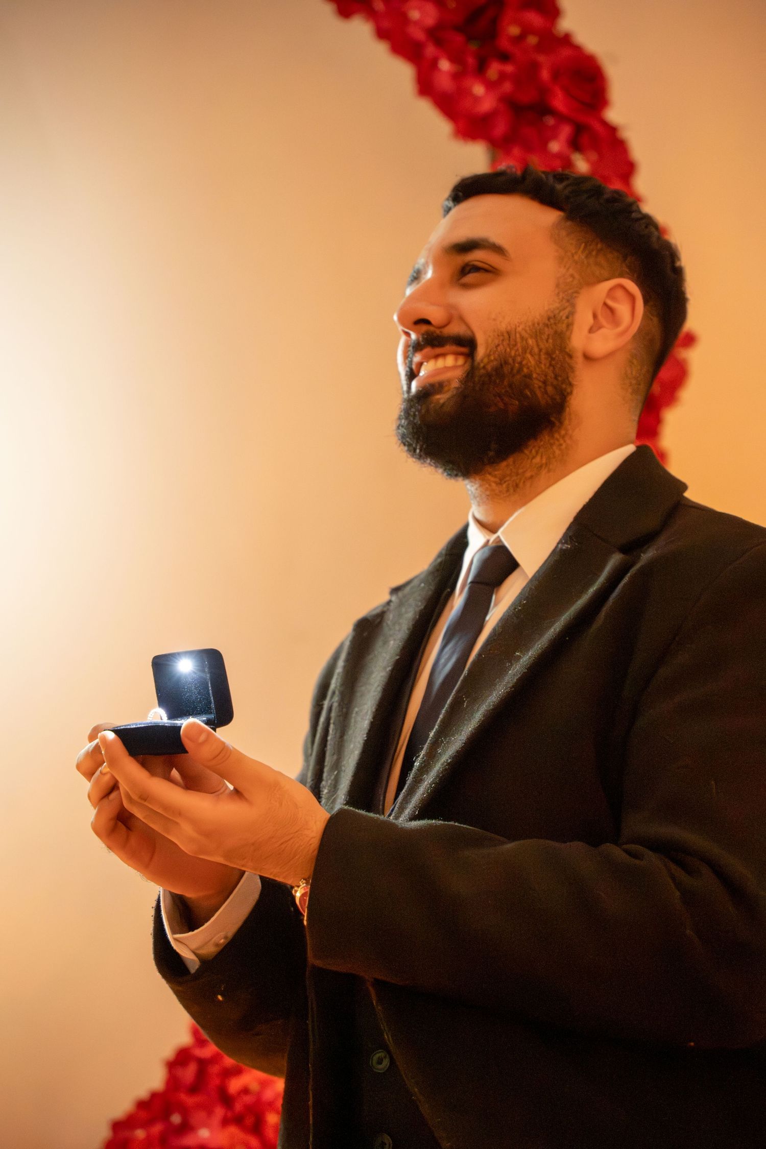groom on one knee, proposing looking up at bride. Tied in Time Photography.