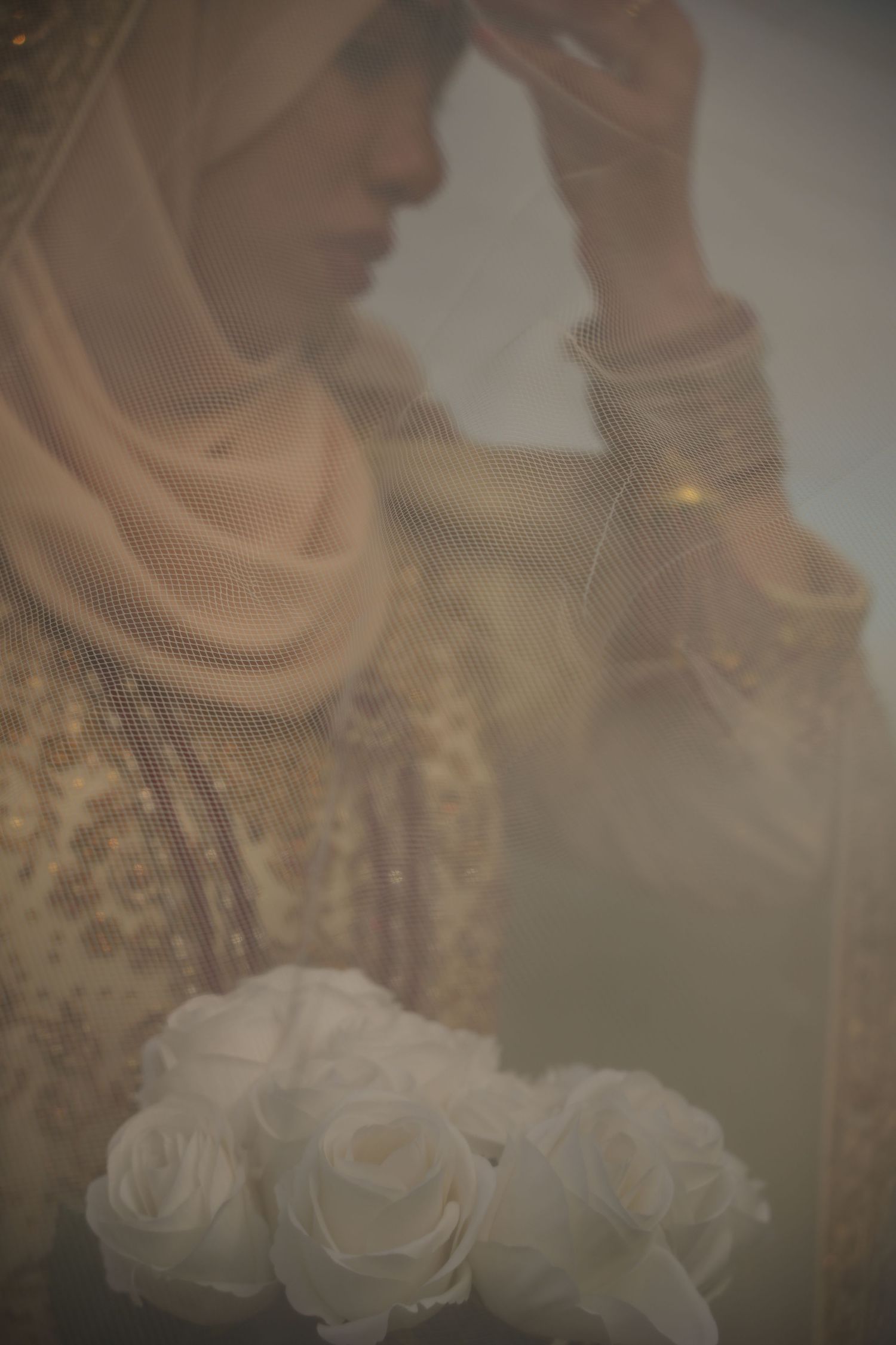 bride adjusting hijab under white veil. Tied in Time Photography.