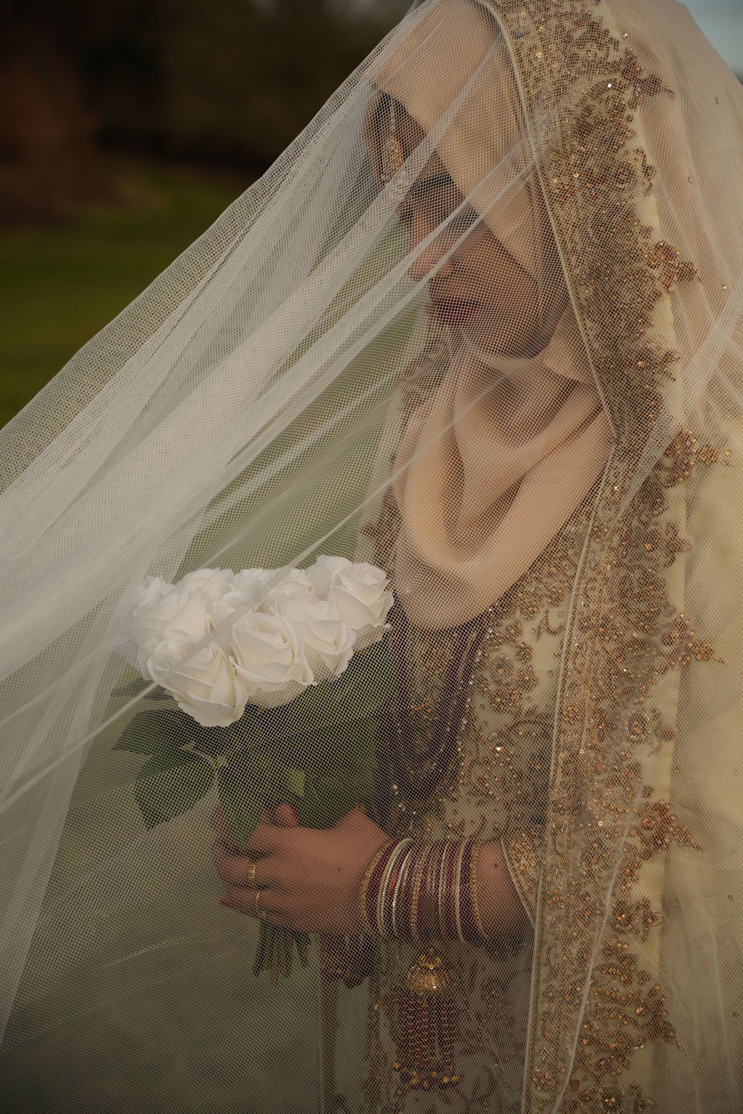 white roses and bridal details. red and gold bridal outfit. under white veil. Tied in Time Photography.