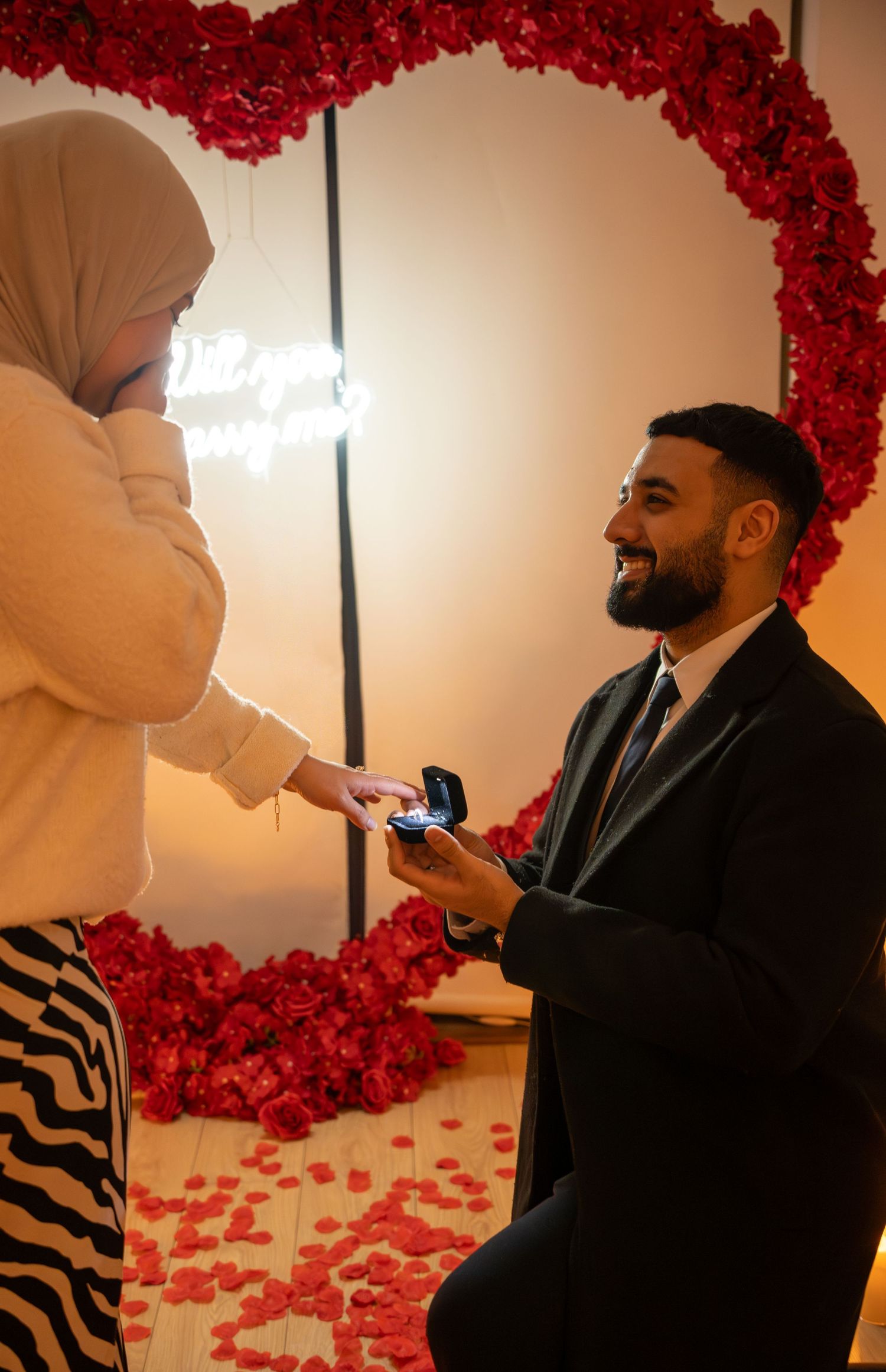 groom on one knee, proposing and looking up at bride. bride covering her mouth. Tied in Time Photography.