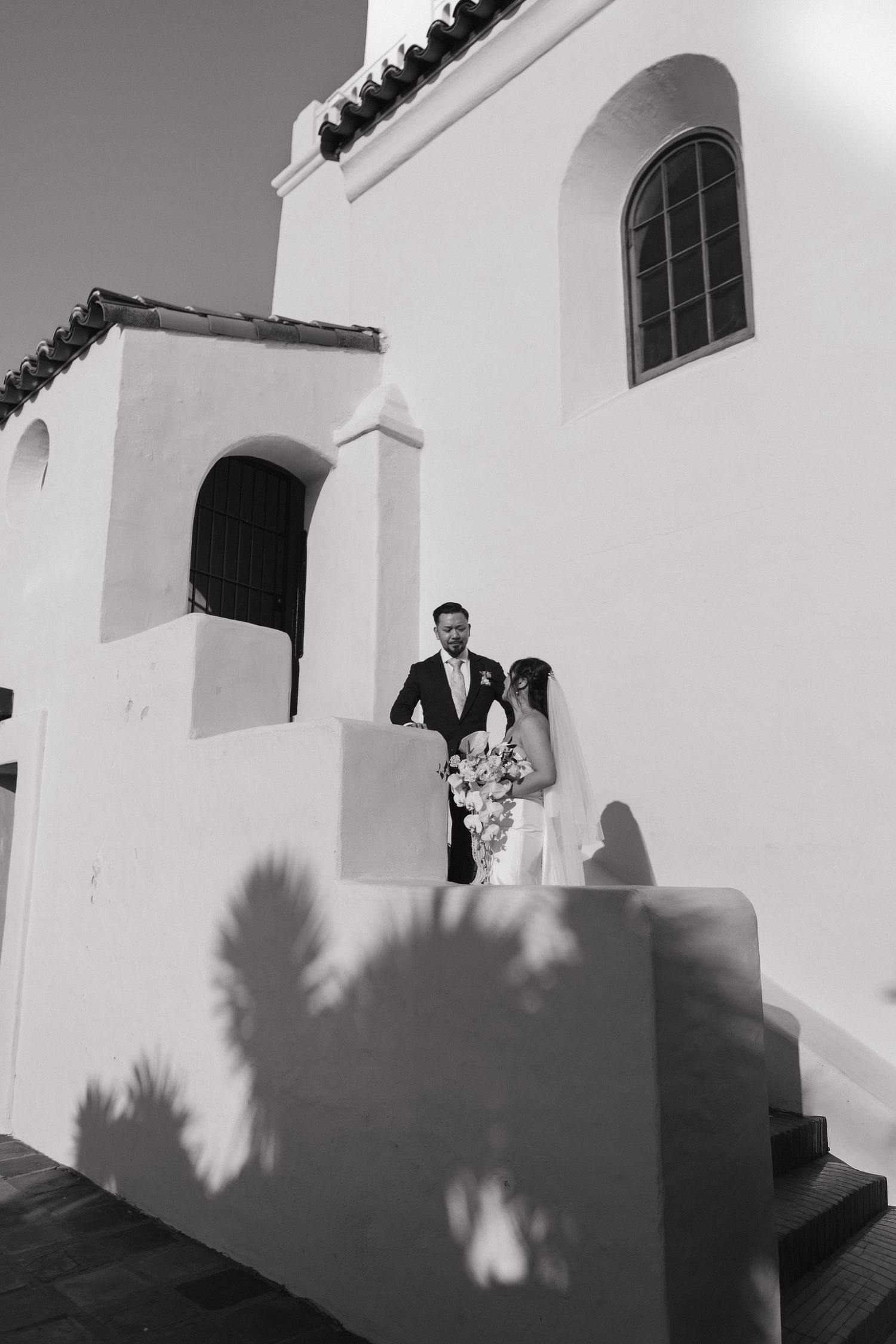 Black and white architectural wedding photos showing dramatic shadows against a white building exterior.