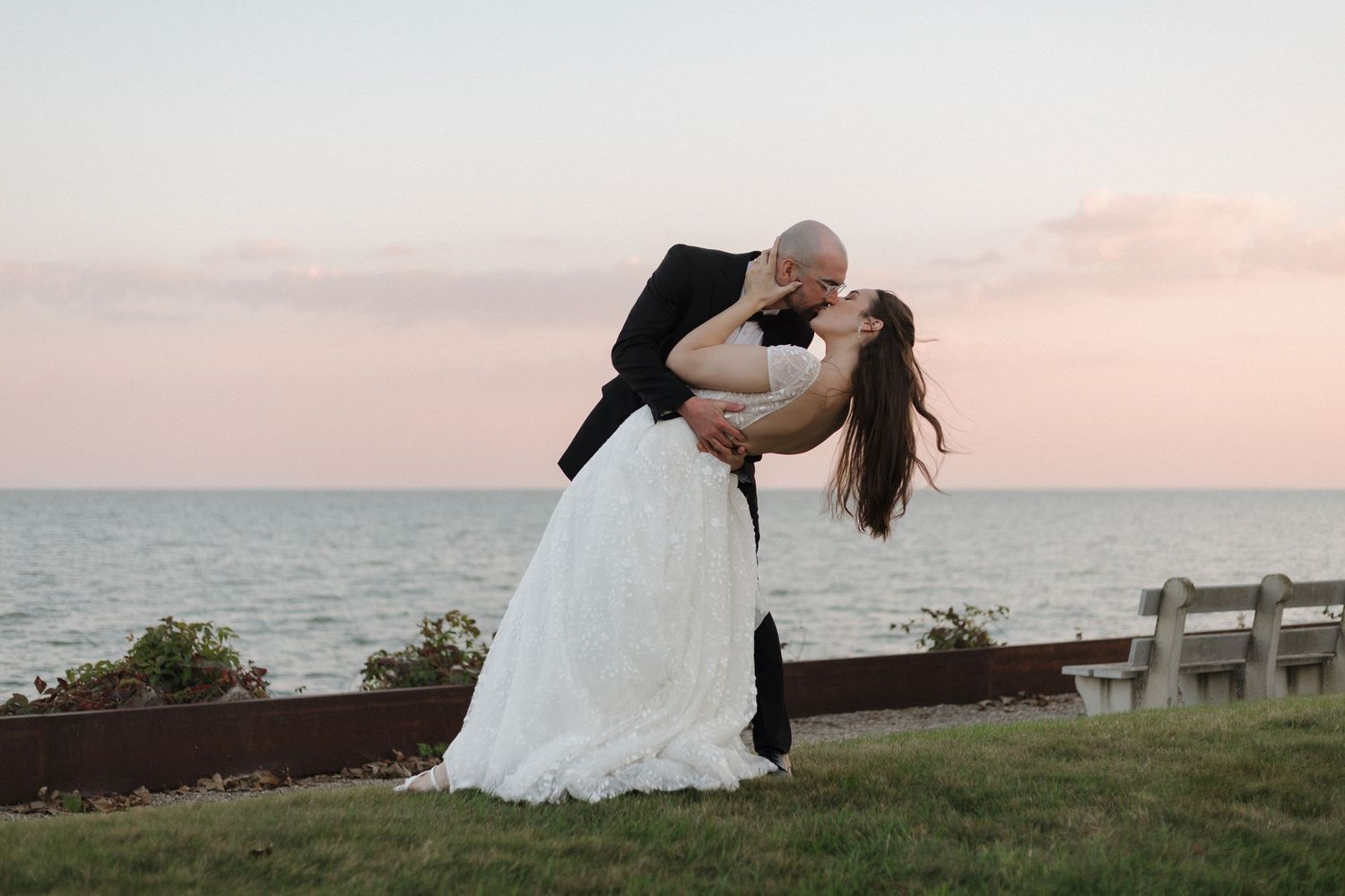 A couple shares intimate moments at sunset against a scenic coastal backdrop.