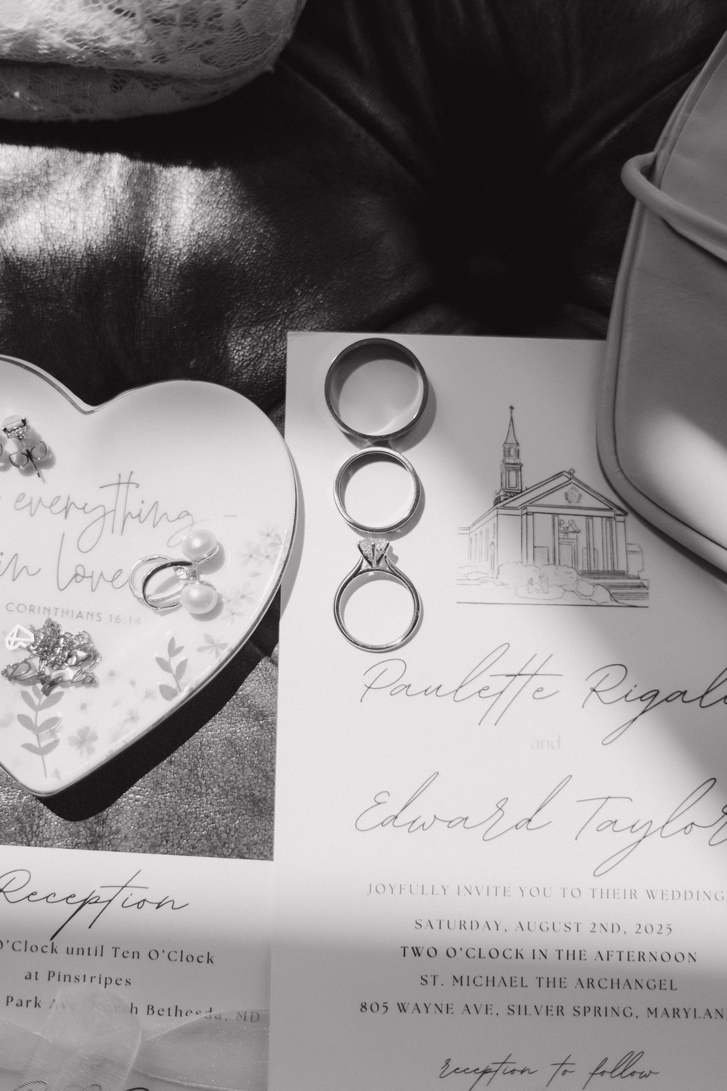 Wedding invitation details and rings photographed in artistic black and white style.