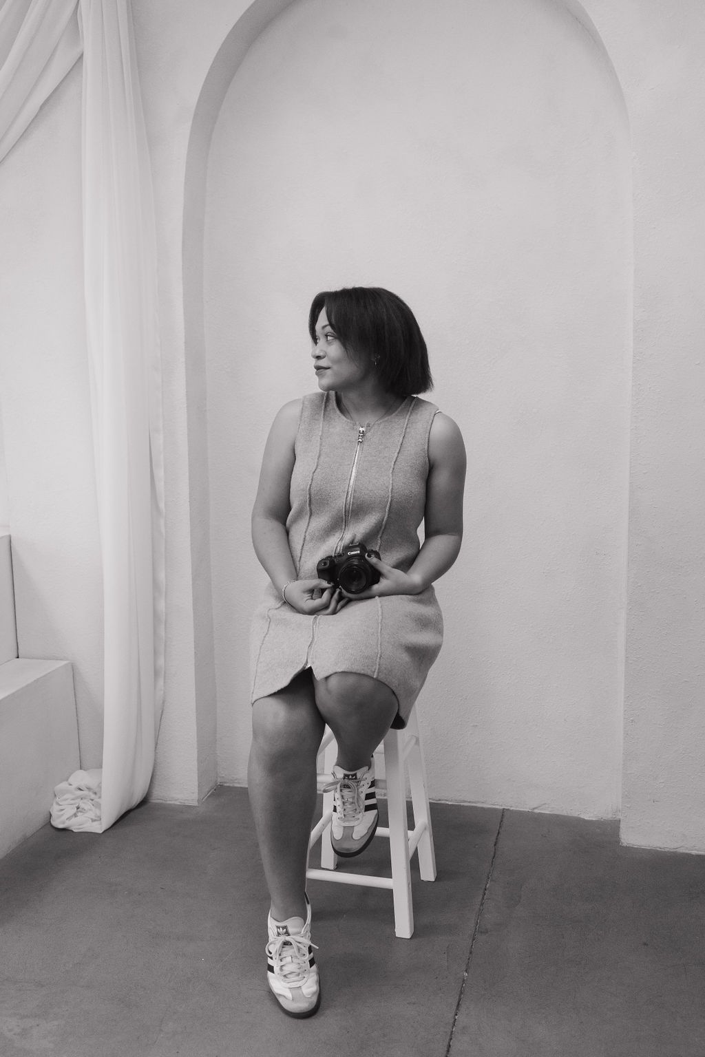 Artistic black and white portrait series showing seated poses in an arched room.