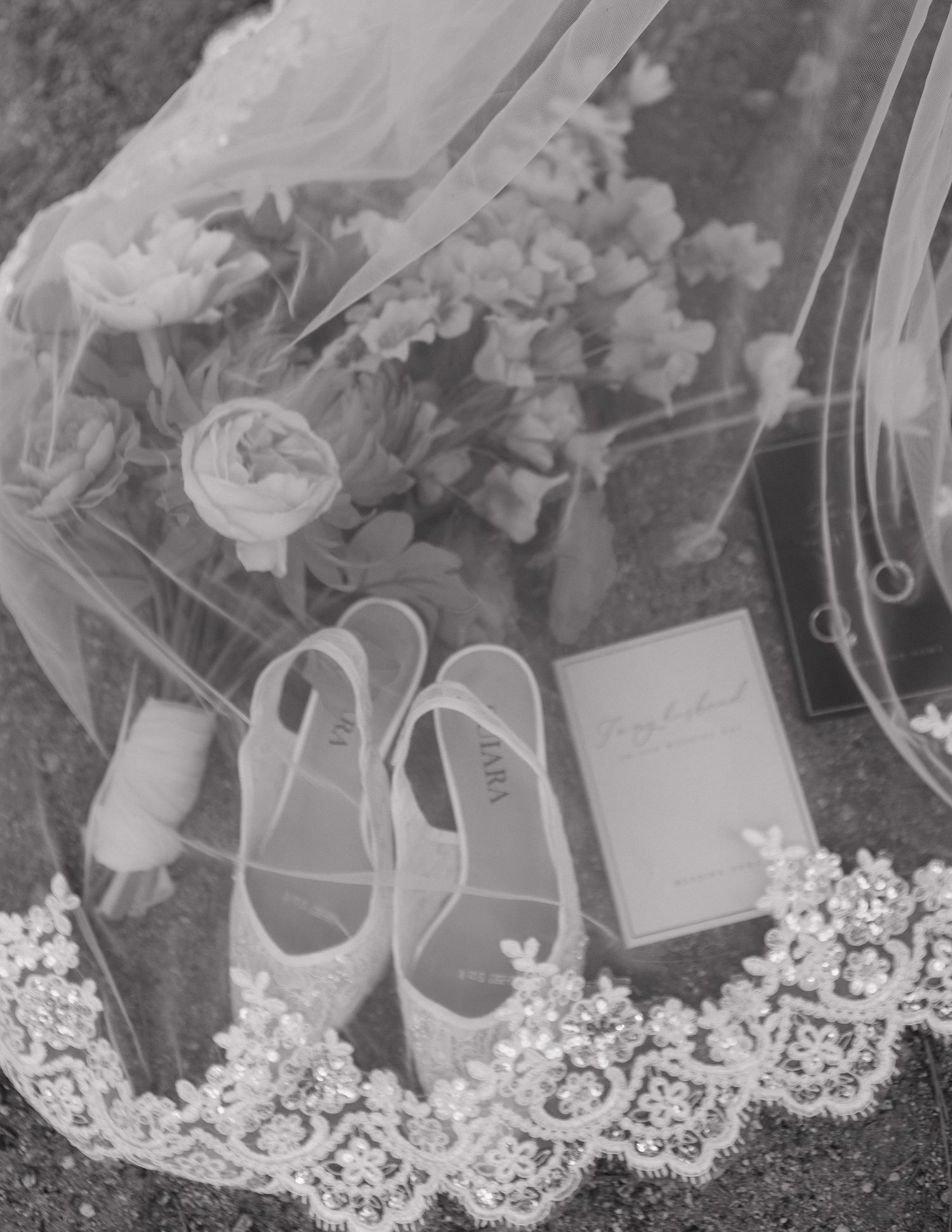 Wedding accessories including shoes and jewelry arranged with delicate lace details in black and white.