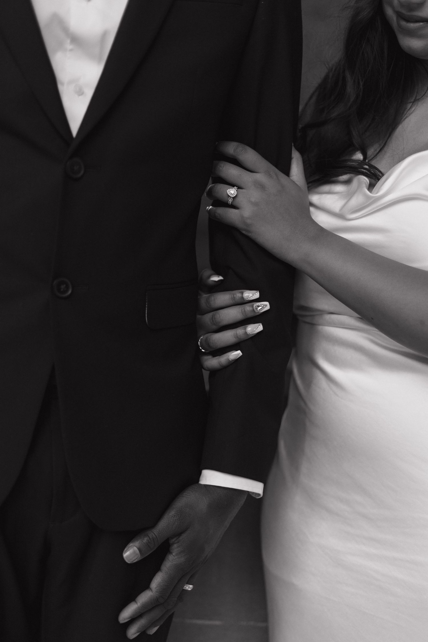Close-up details of formal wedding attire in black and white.
