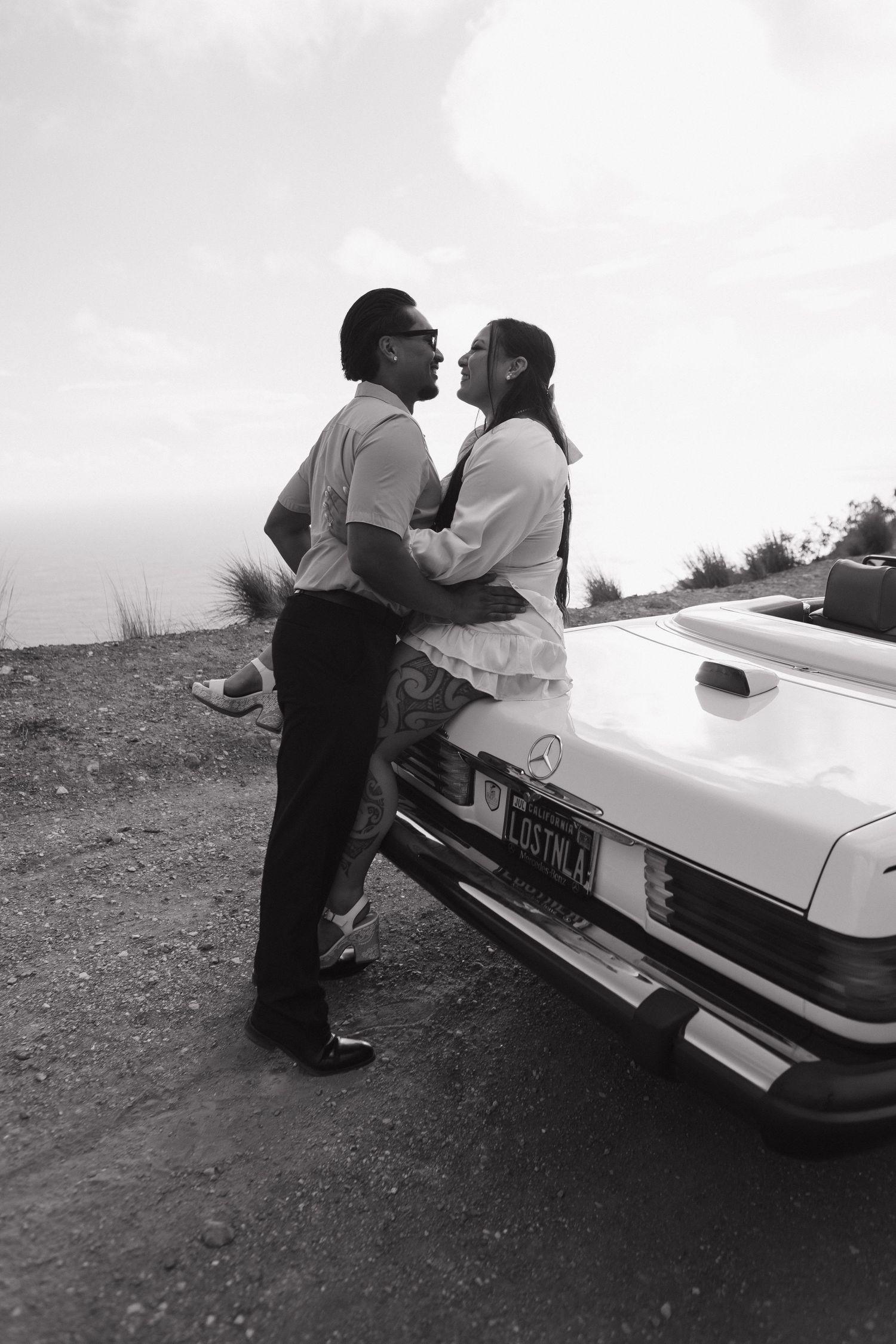 Black and white photo sequence of a couple by a vintage car.
