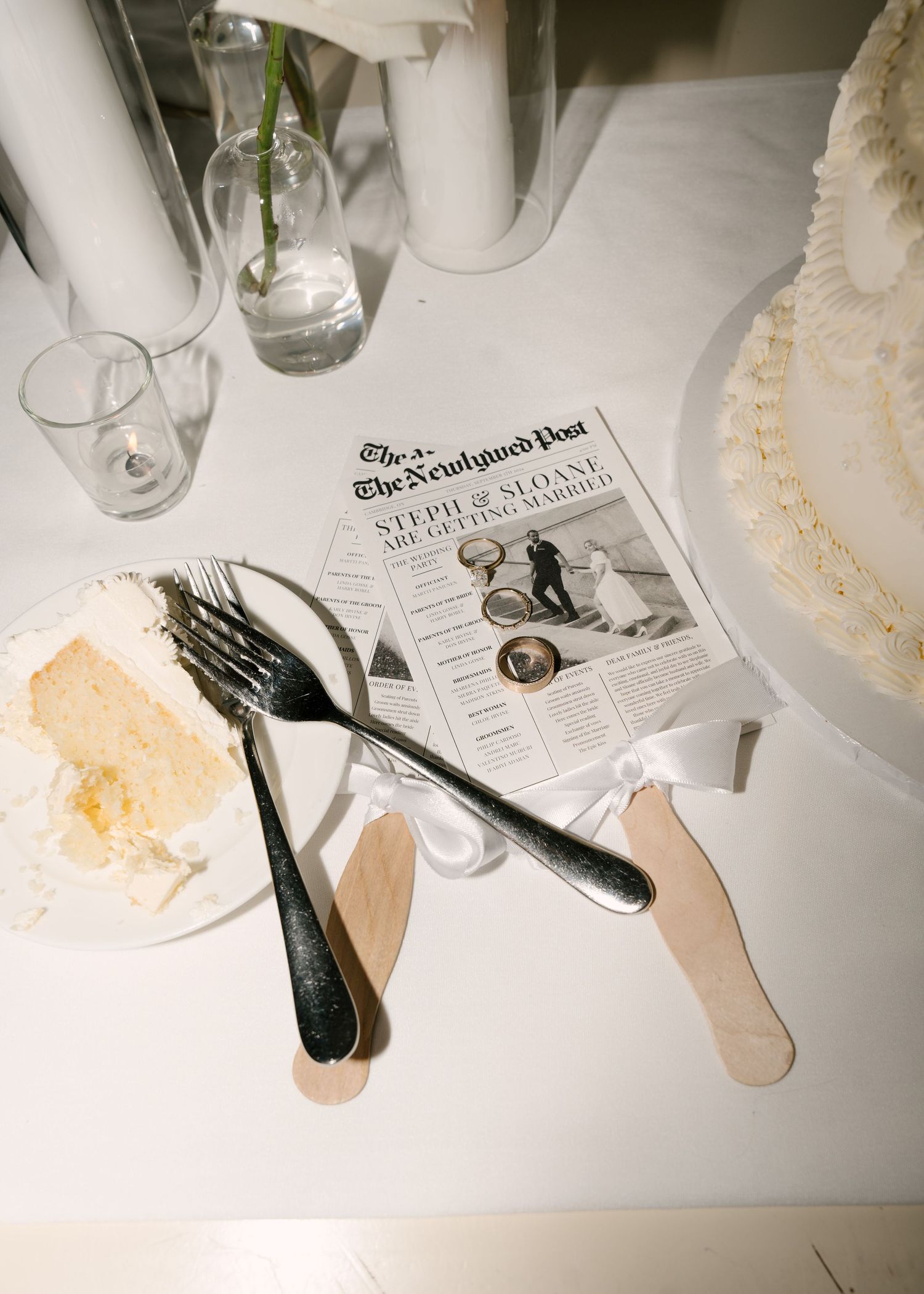 Wedding cake table with custom newspaper announcement reading Steph and Sloane are getting married.