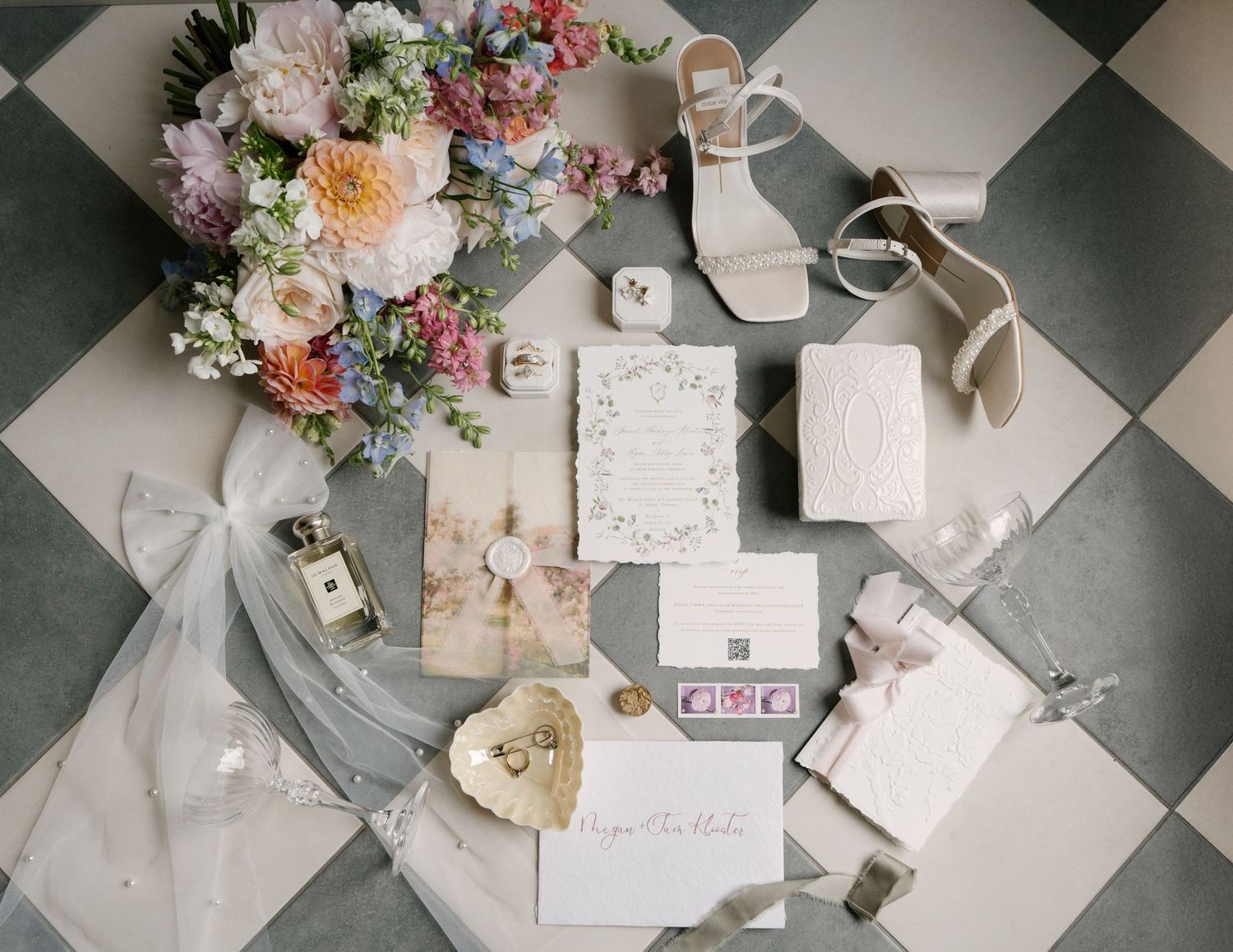 Flat lay of wedding details including floral bouquet, invitations, shoes, and accessories.