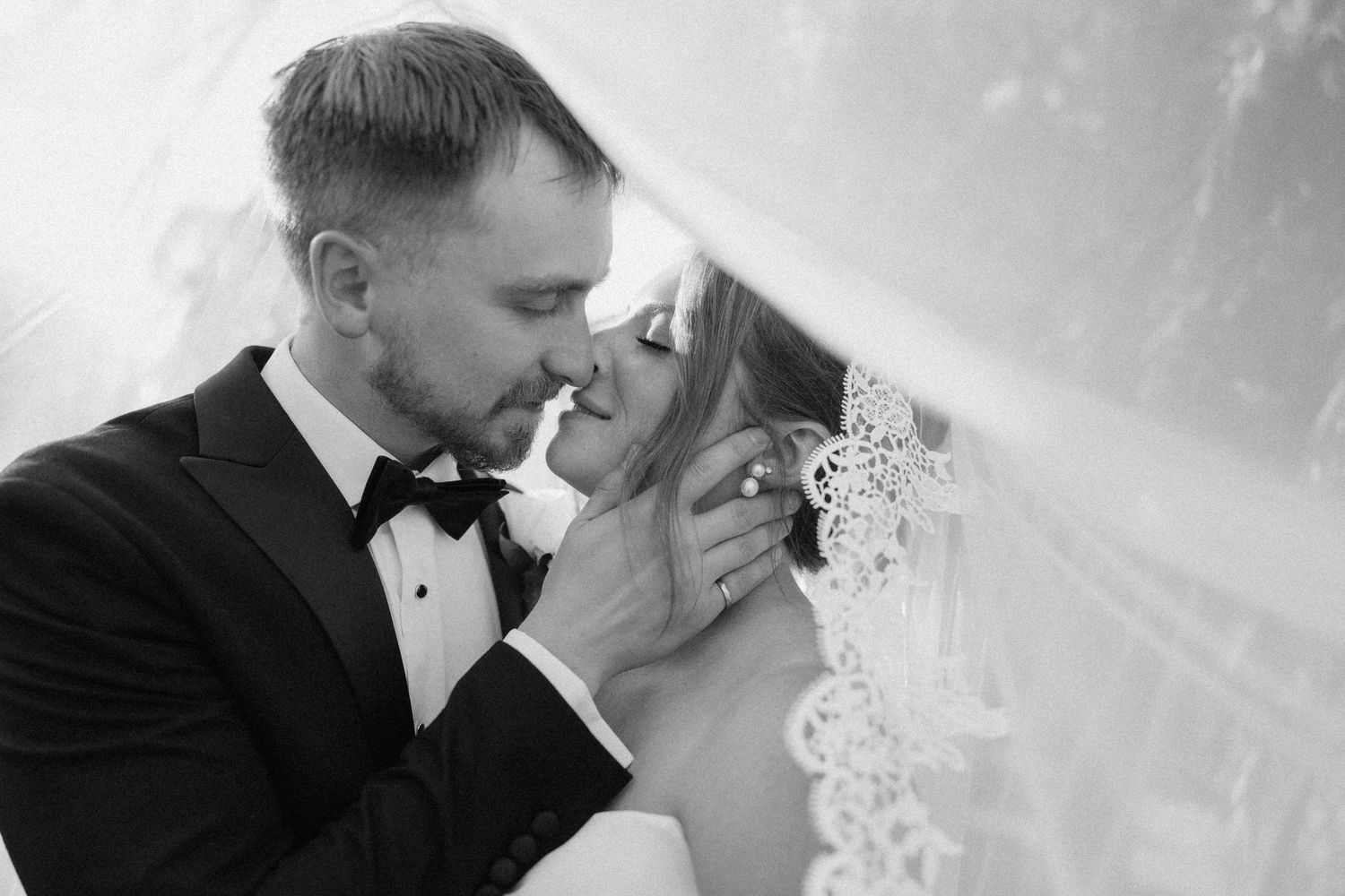 Romantic black and white photo of bride and groom nearly kissing under a lace veil  at Pillar and Post.
