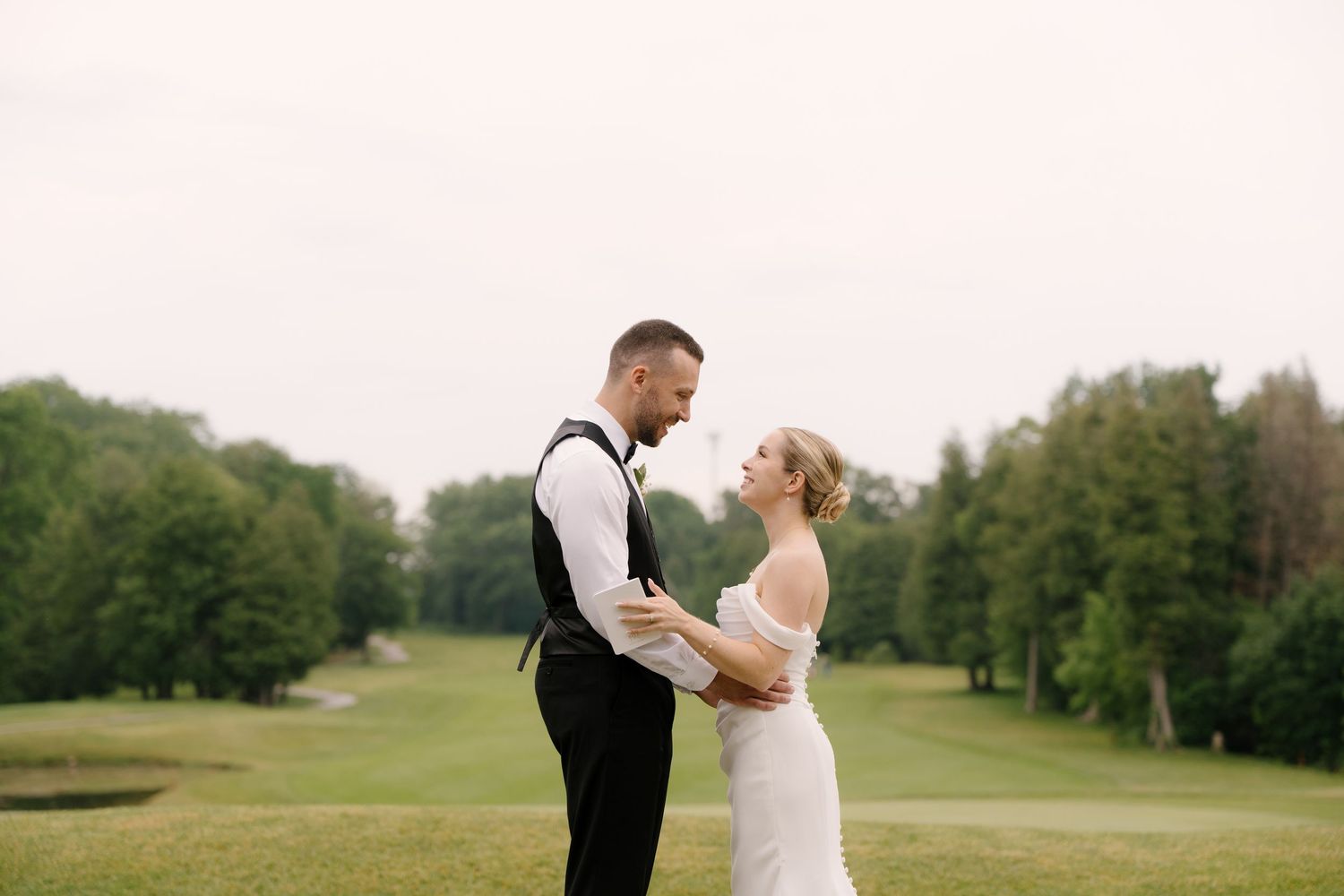 Bride and groom share a romantic moment on a lush green Guelph golf course on their wedding day.