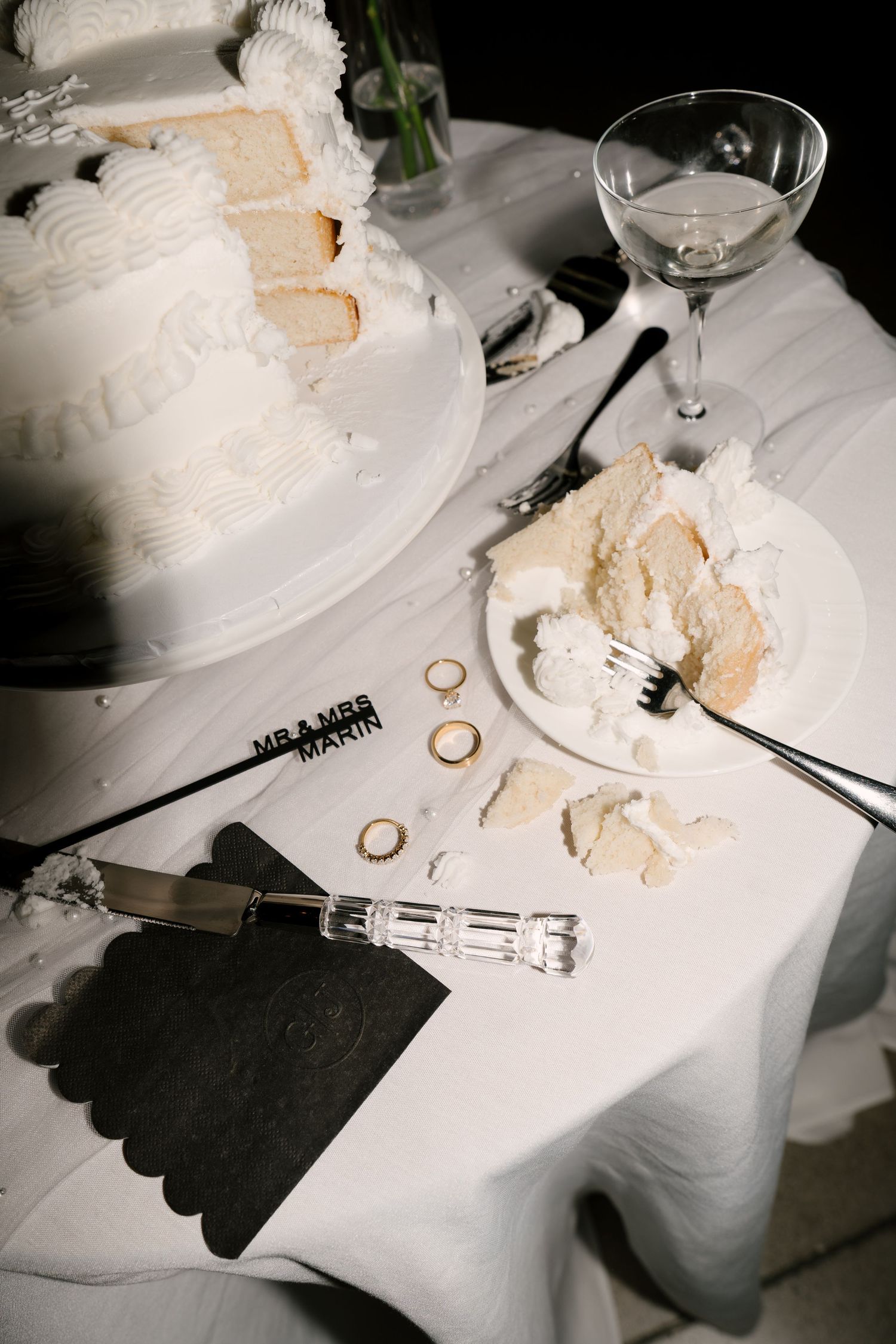 Close-up of sliced white wedding cake on table with Mr and Mrs cake topper.