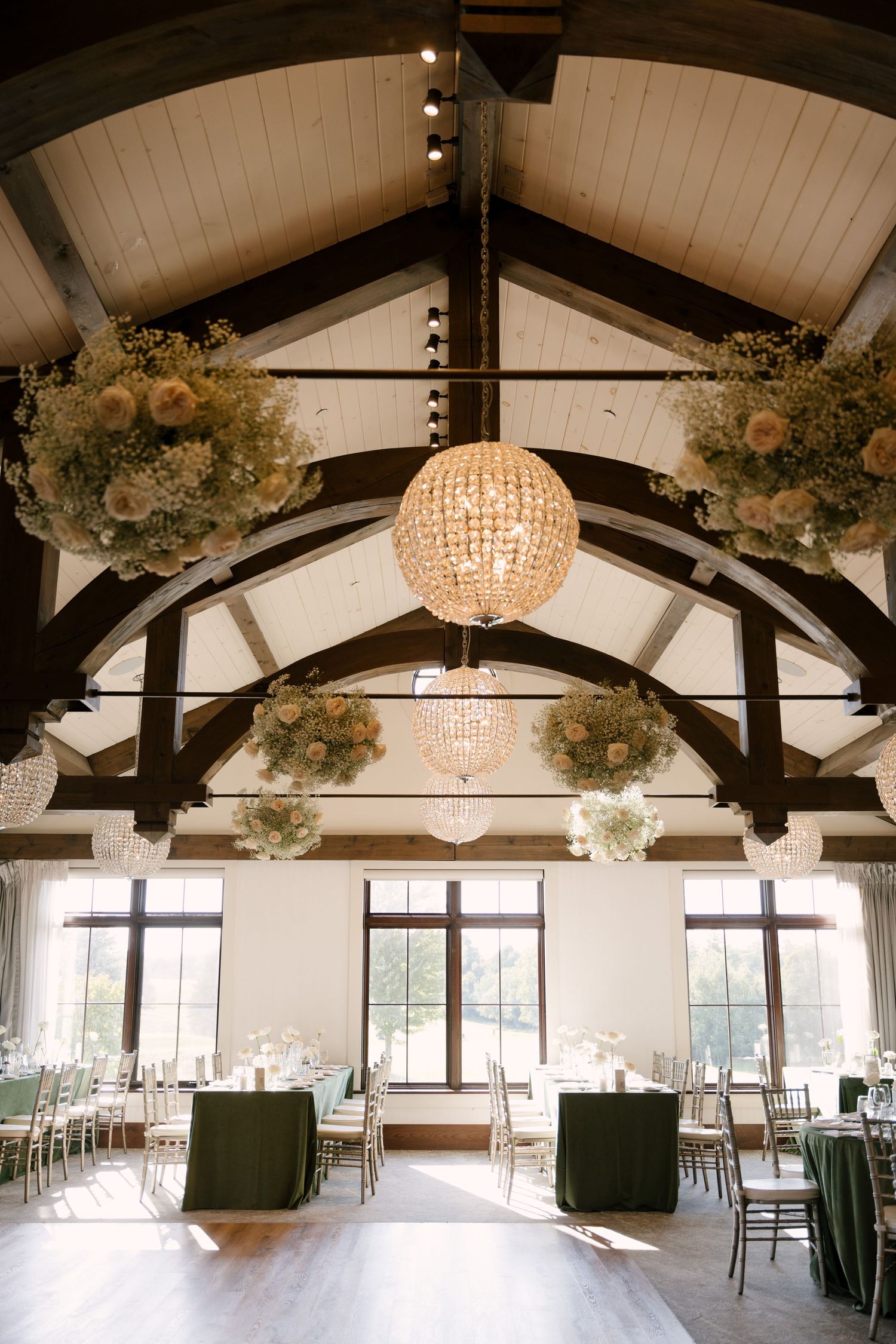 Grand wedding reception hall with vaulted wood beam ceiling and crystal globe chandeliers at Whistle Bear wedding venue.
