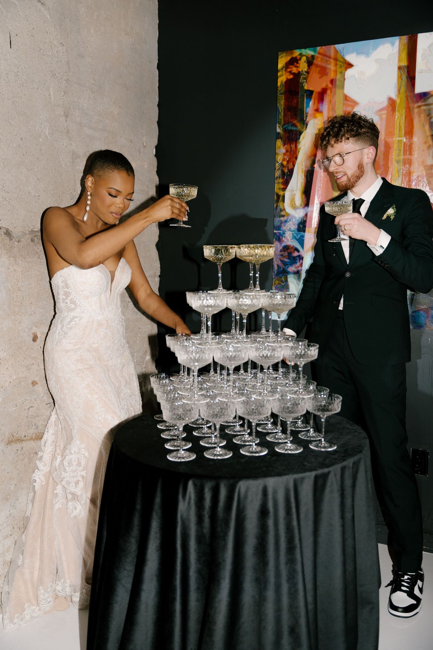 Bride and groom toasting beside a crystal champagne tower at their elegant Tapestry Hall wedding reception.