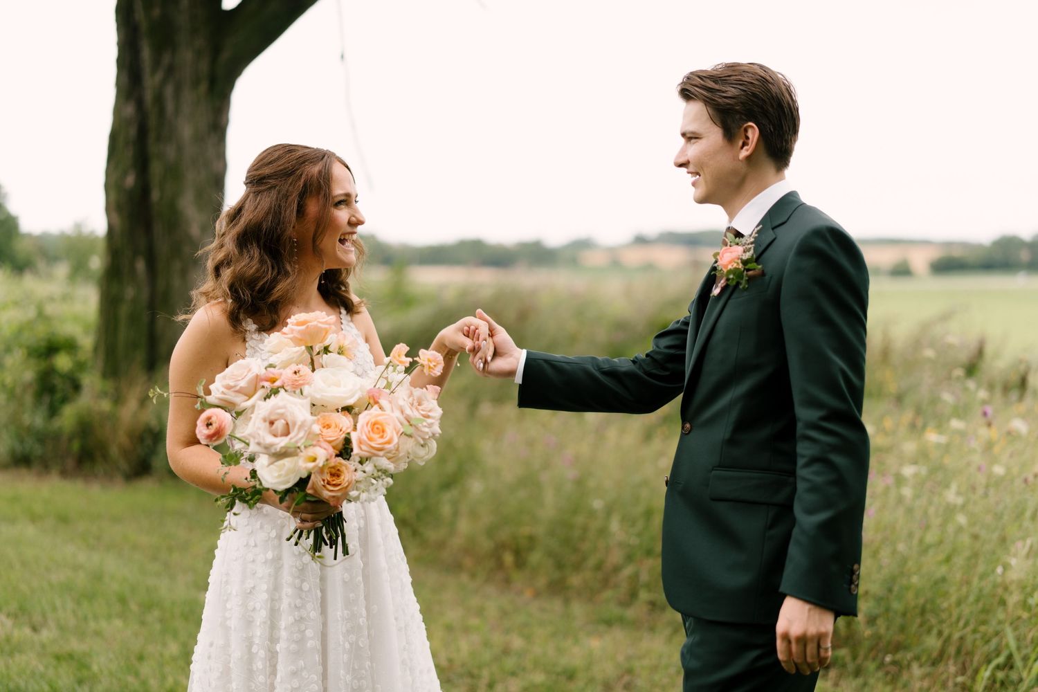 Bride and groom sharing playful pinky promise moment in lush outdoor garden setting.