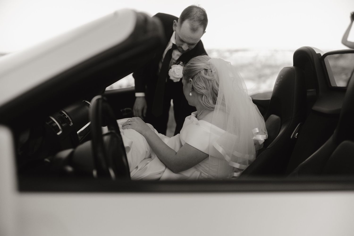 Black and white wedding photos showing intimate moments through car window frames.