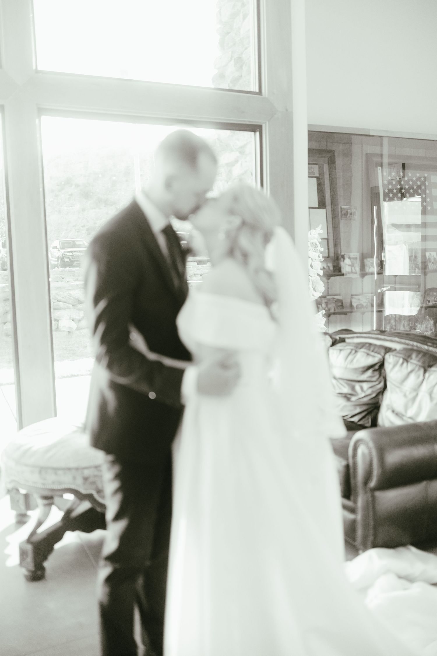 Couple's first dance captured in soft focus through window light.
