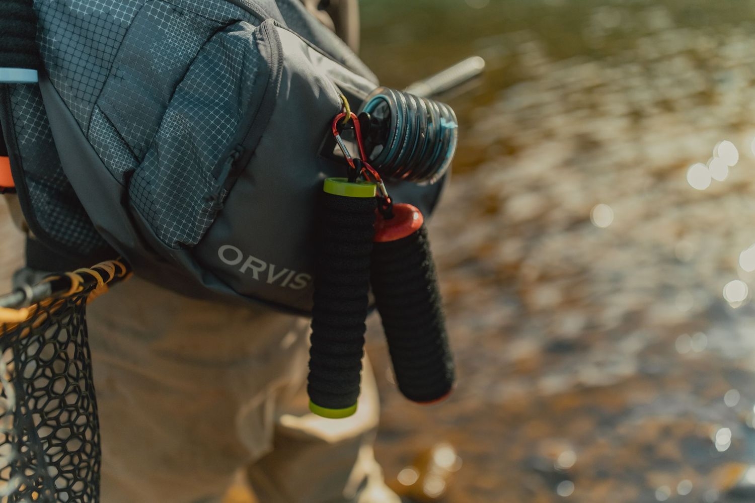Close-up of outdoor gear and equipment against a blurred natural background.