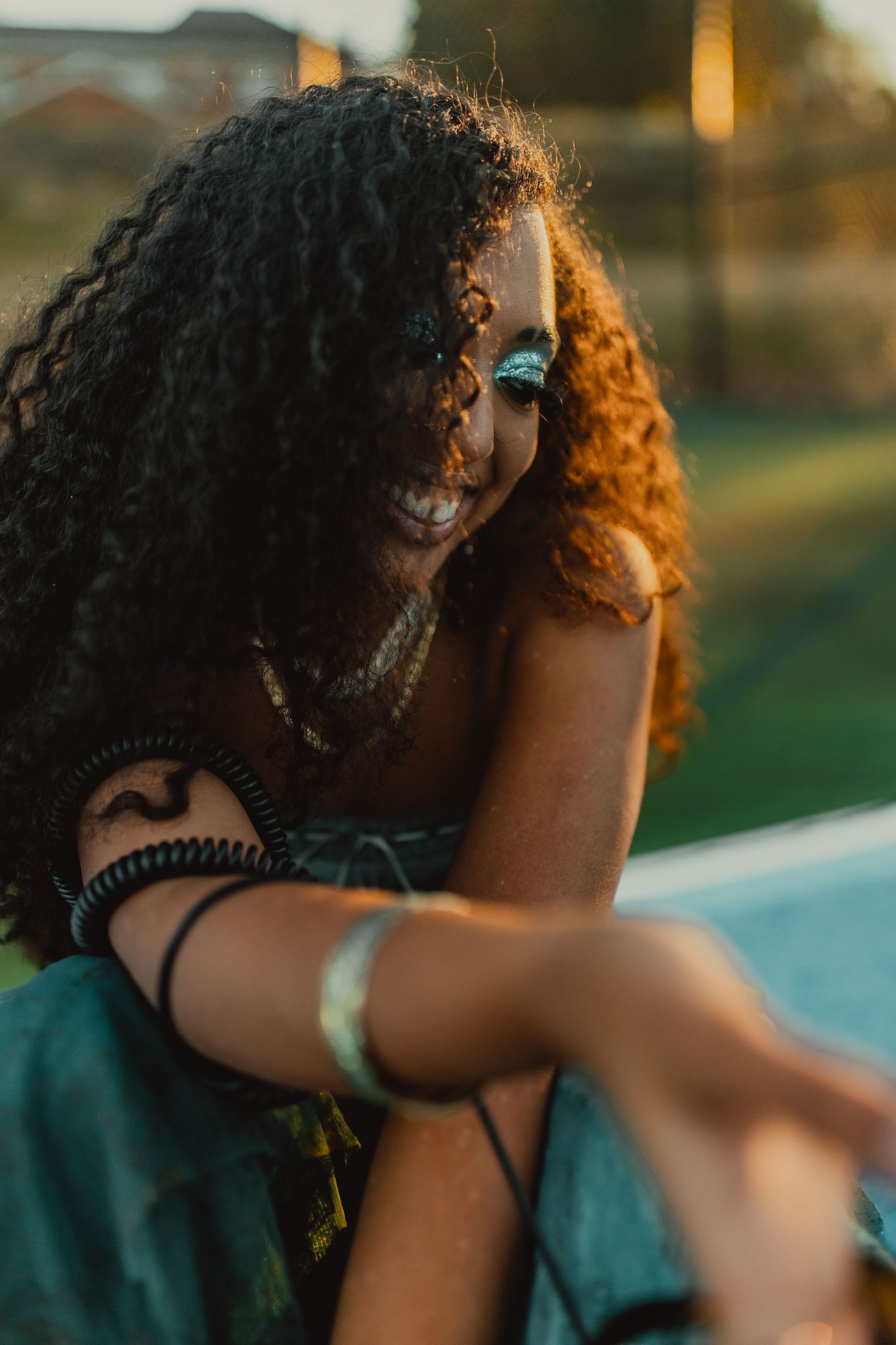 Close-up profile shots with warm sunset lighting and curly hair in focus.