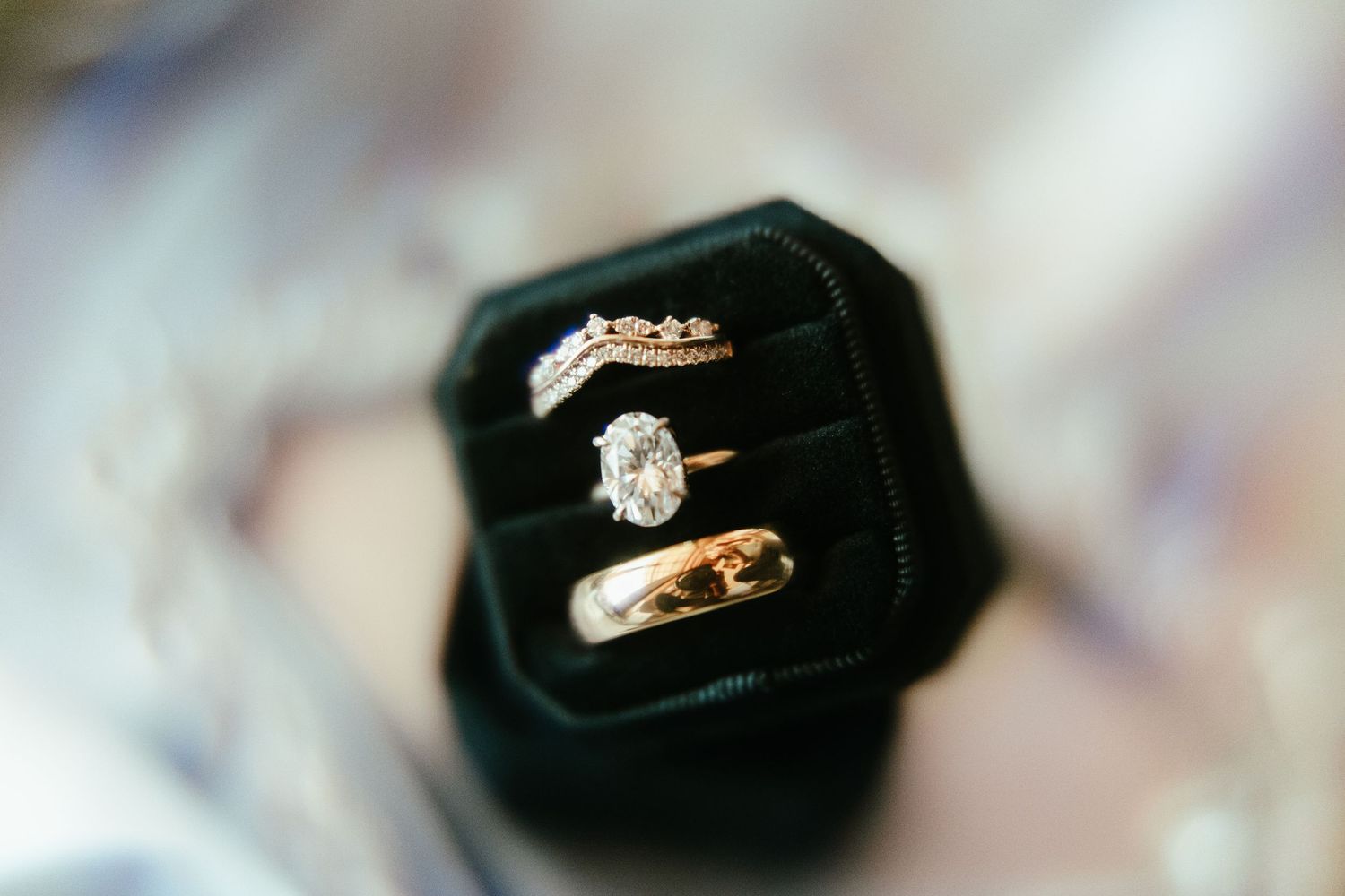 Close-up of diamond engagement rings displayed in black velvet boxes.