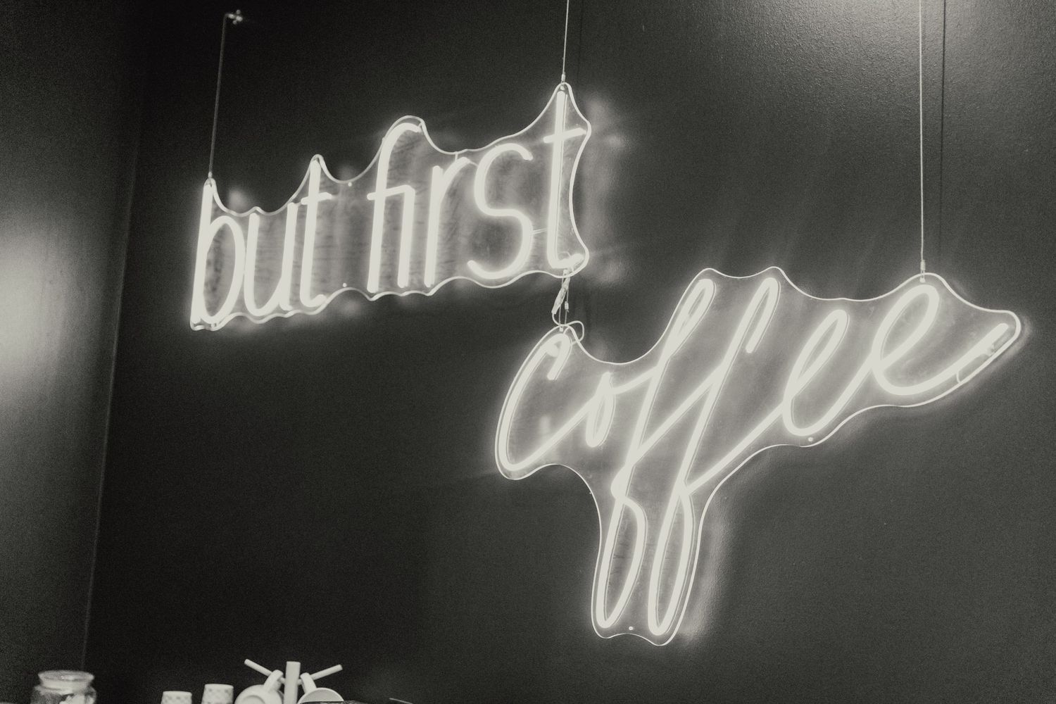 Artistic black and white neon light installation with cursive text.