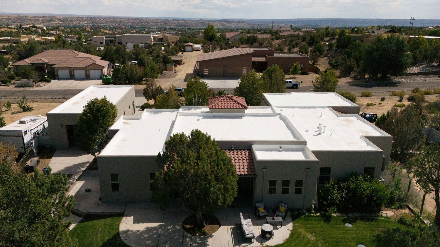 Panoramic aerial view of a suburban residential neighborhood with terra cotta roofs and desert landscaping in Arizona.