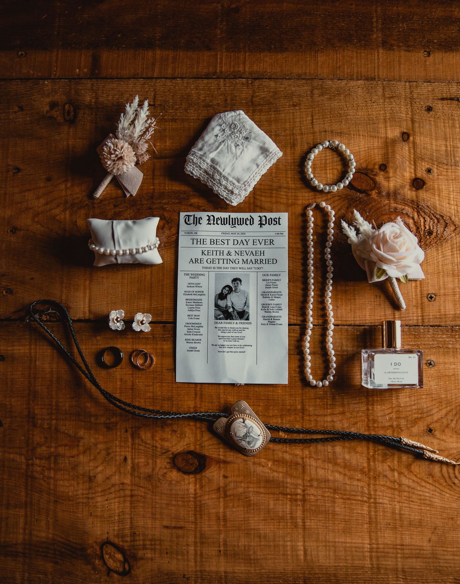 Vintage wedding details arranged on wooden surface including newspaper and jewelry.