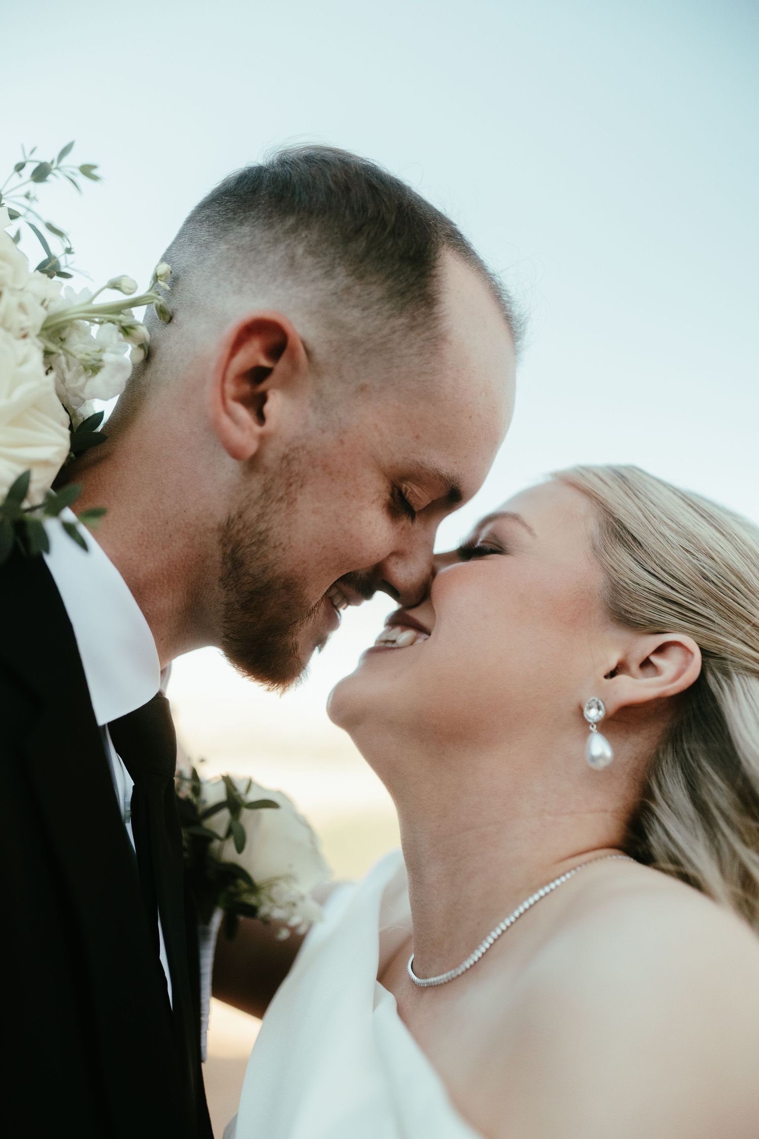 Romantic wedding couple sharing intimate moment during sunset ceremony.