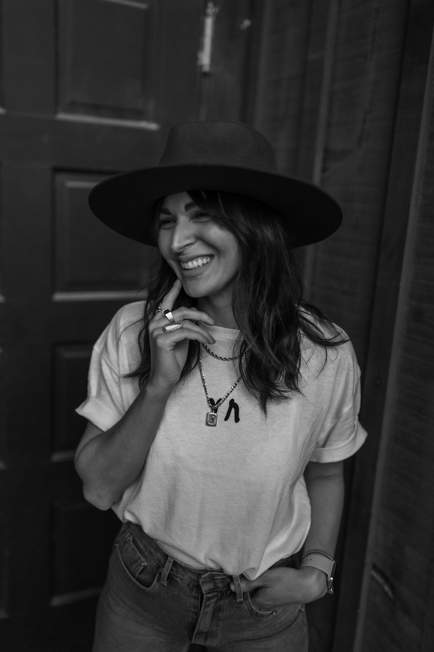 Black and white portrait series showing joyful expressions and a wide-brimmed hat.