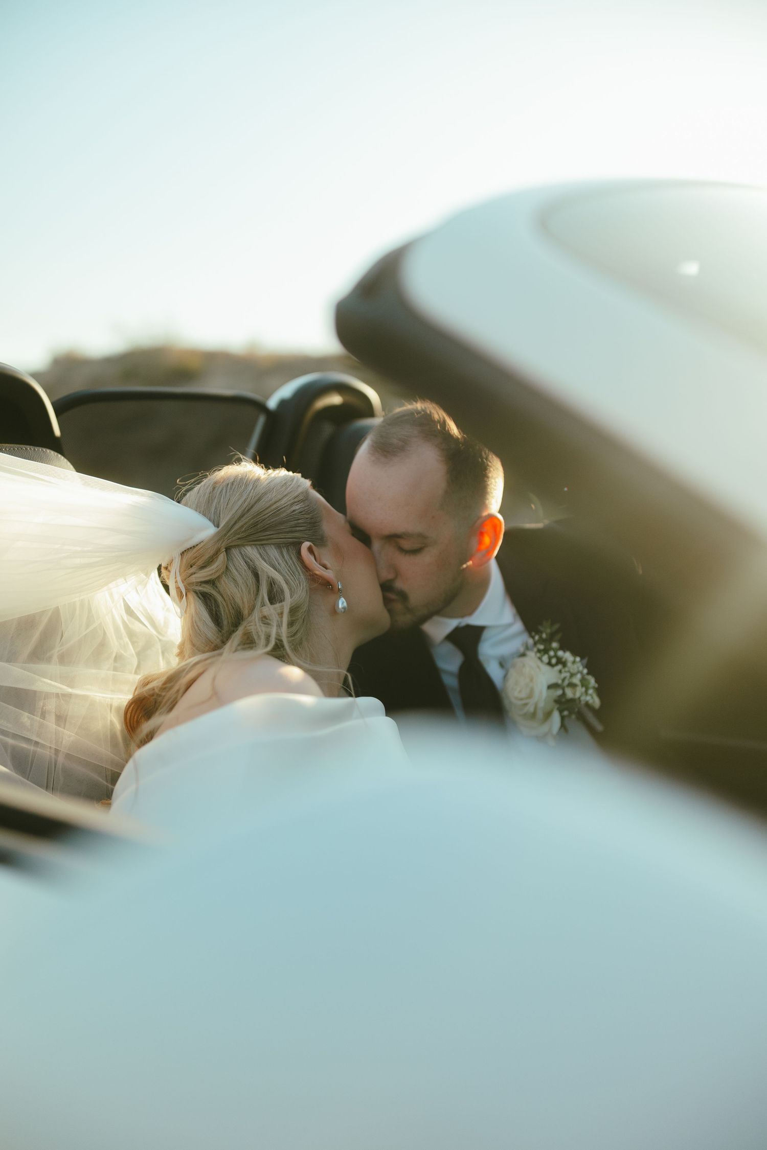 A romantic wedding couple shares intimate kisses in a series of close-up shots at sunset.