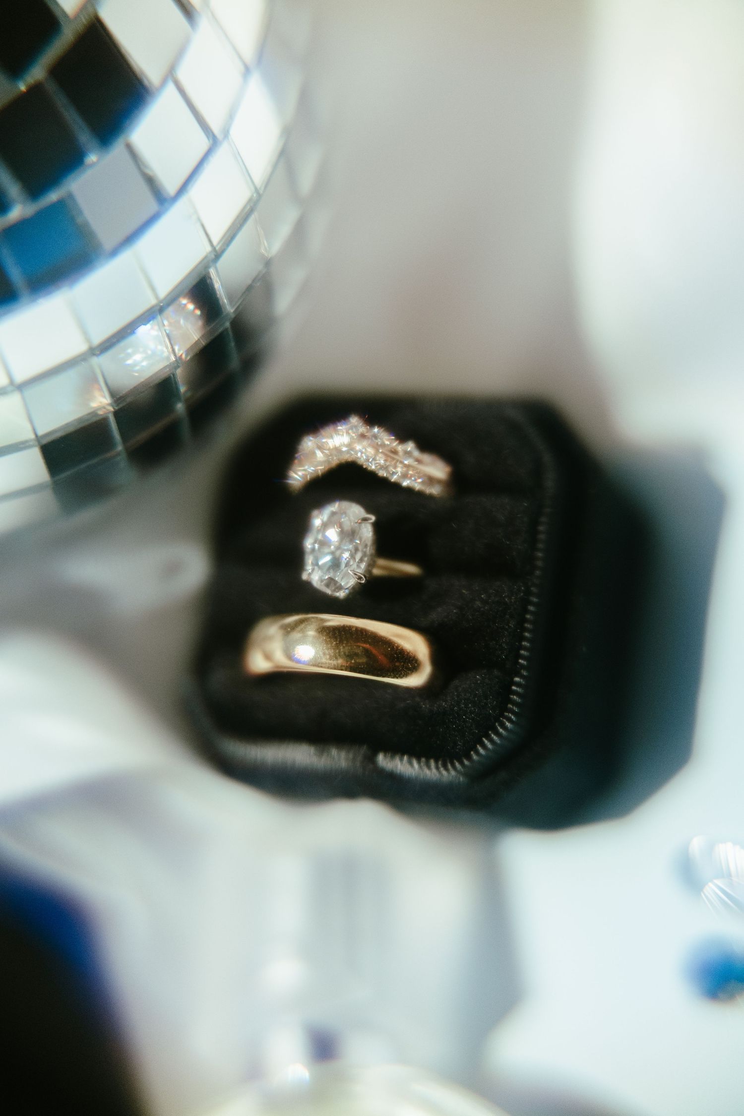 Diamond engagement rings showcased in black display boxes with dramatic lighting.