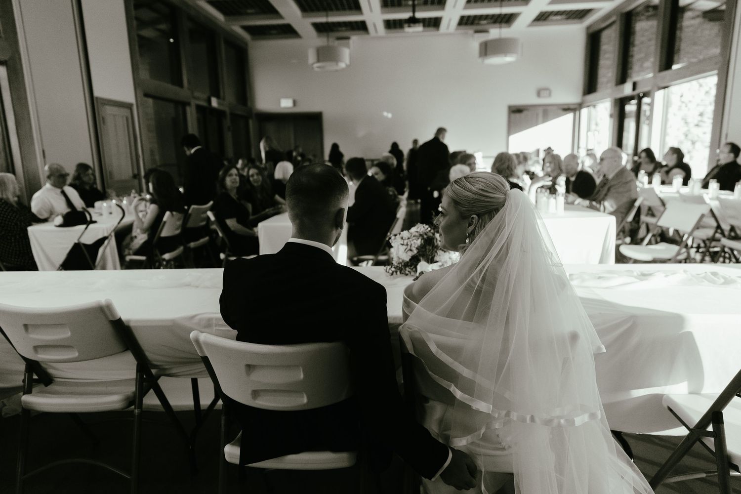 Wedding reception venue with guests celebrating at decorated tables.